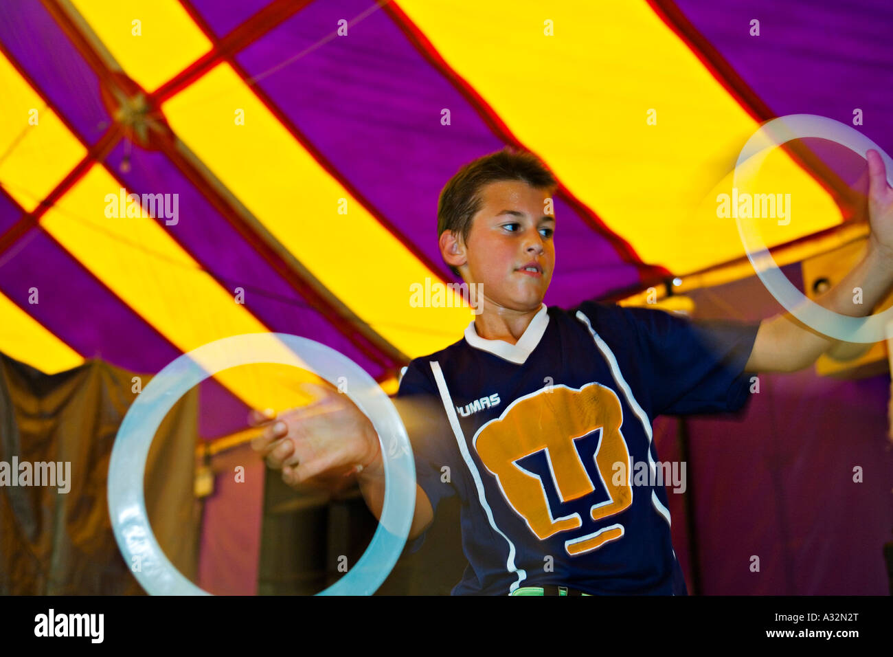 Mexiko San Miguel de Allende junge Praxis Jonglieren zwei Ringe in der Schule für Zirkus Darsteller bunte großes Zelt Stockfoto