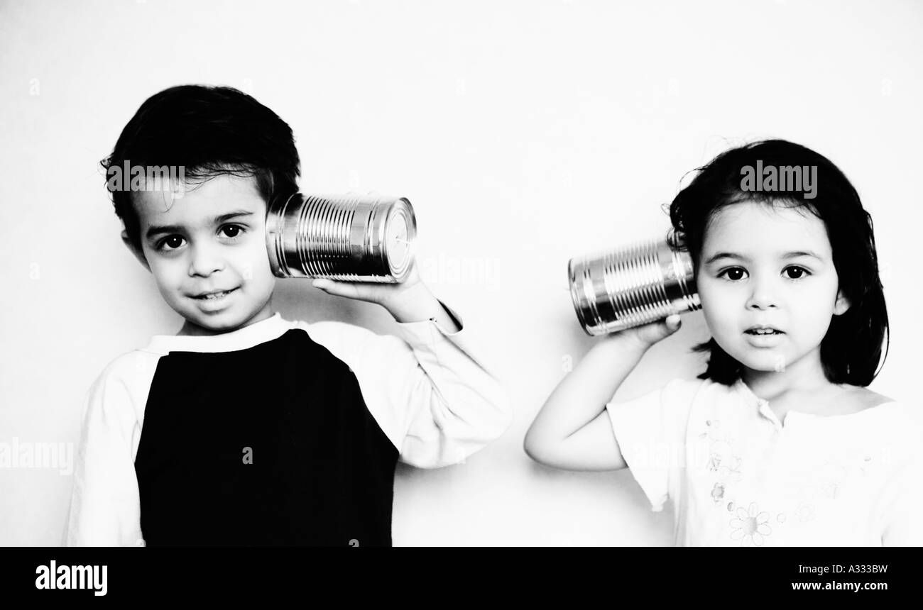 Kinder sprechen mit Spielzeug Blechdose Telefon miteinander Stockfoto