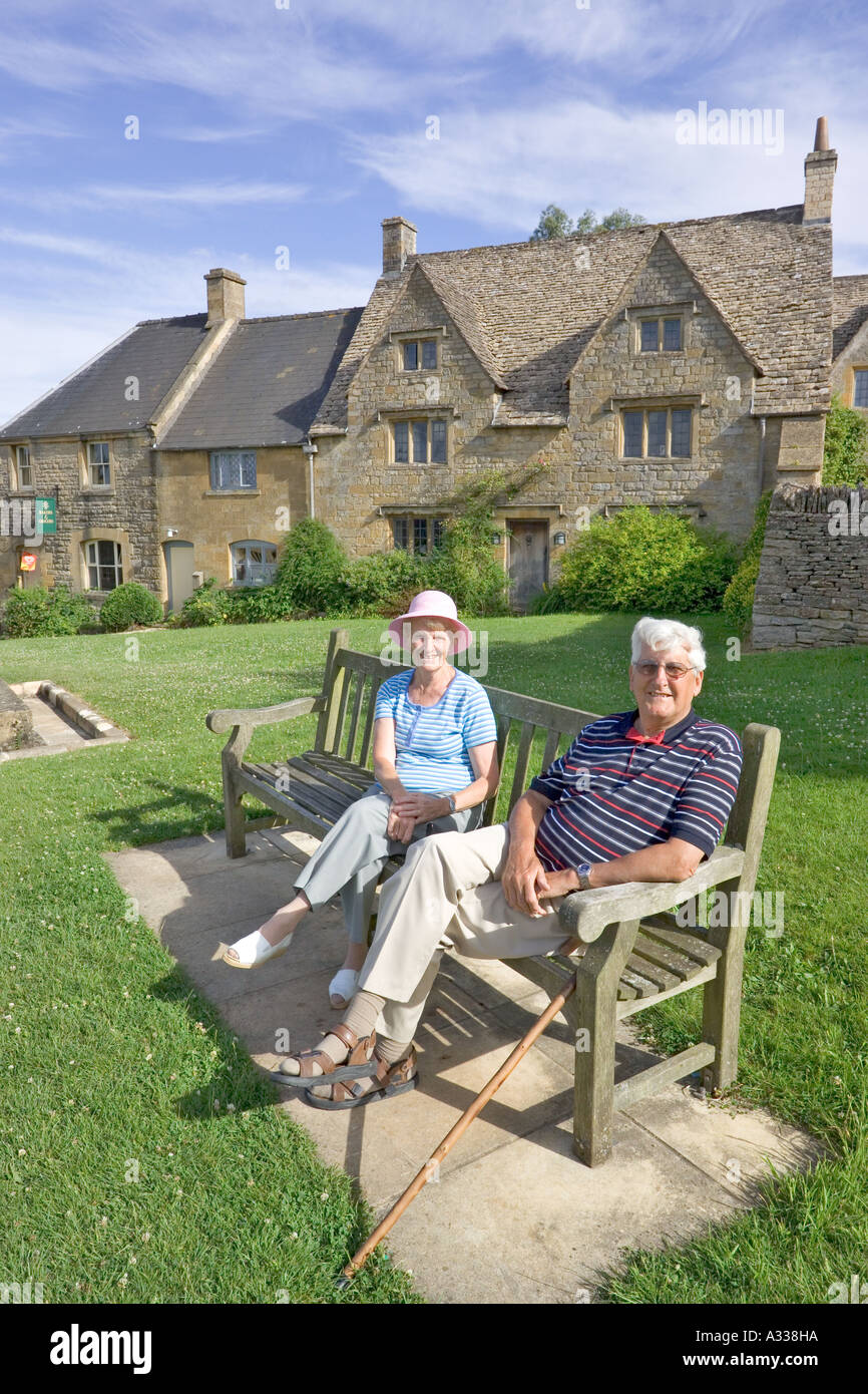 Besucher, die den frühen Abendsonnen im Cotswold Dorf Guiting Power, Gloucestershire, Großbritannien, genießen Stockfoto