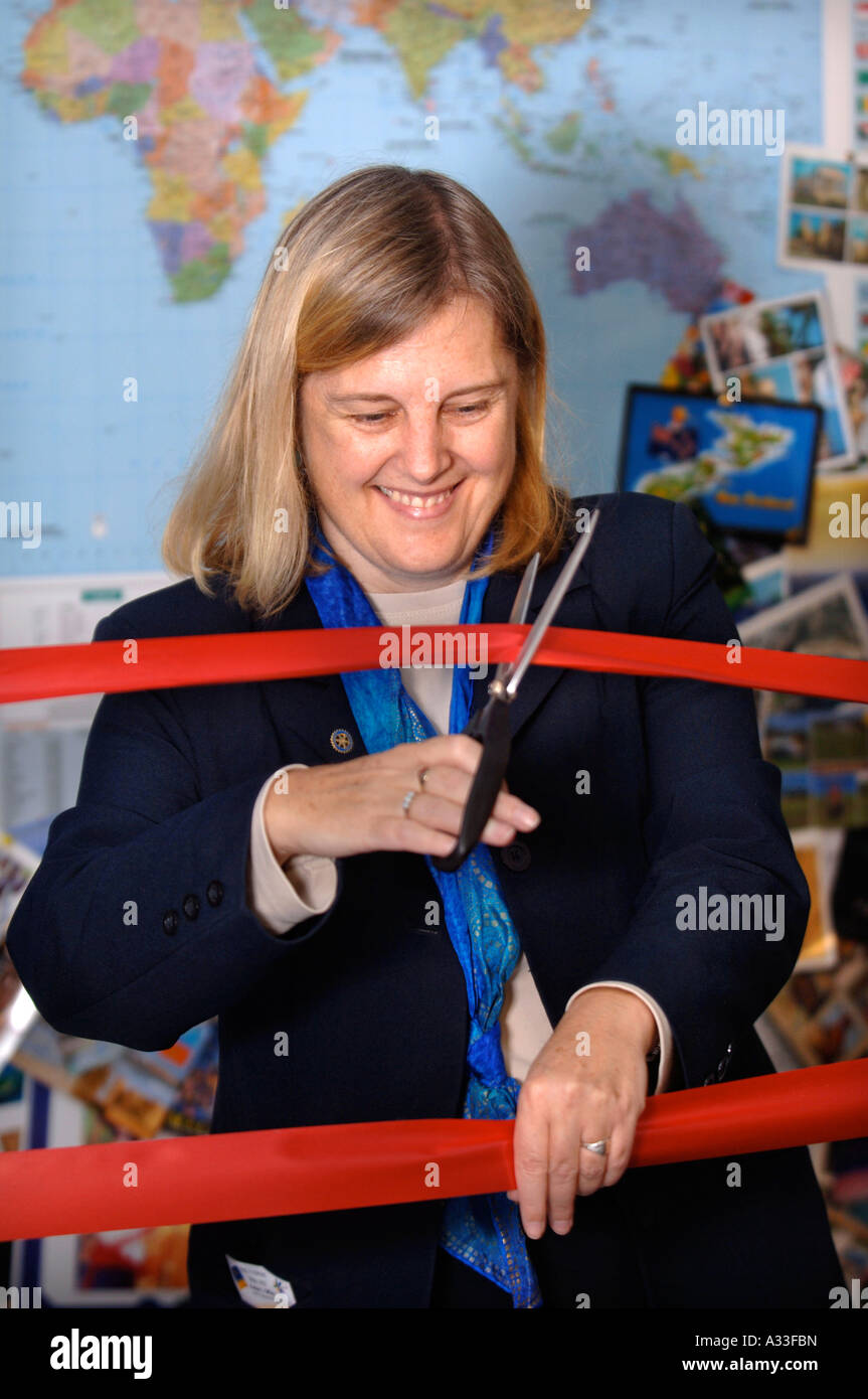 DER BESITZER EINES KLEINEN UNABHÄNGIGEN REISEBÜROS SCHNEIDET EINE BÜROKRATIE-UK Stockfoto