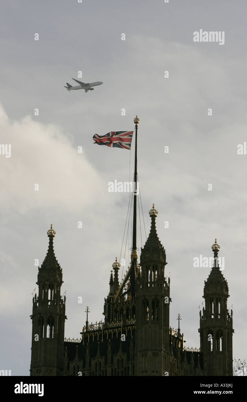 ein Flugzeug fliegt über die Häuser der Victoria Turm Parlamentsgebäude in London england Stockfoto