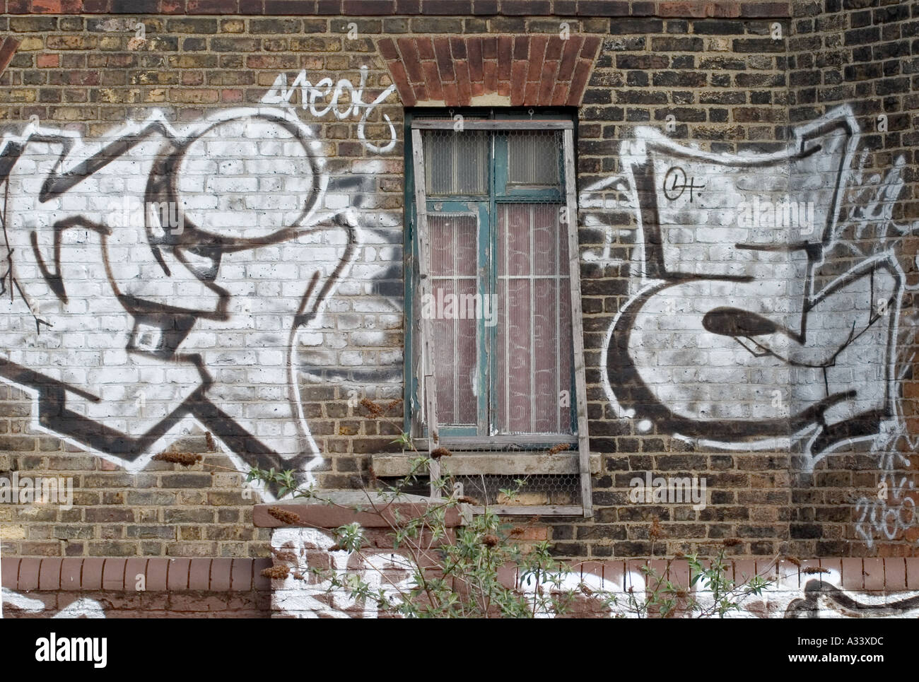 Schäbigen Fenster in Ziegelmauer umgeben von Graffiti. Loughborough Junction, London, England Stockfoto