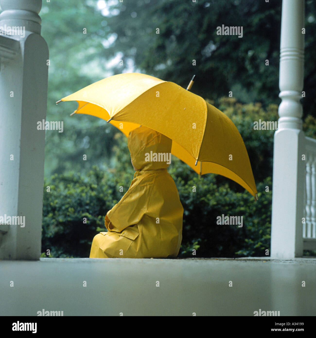 Ein Kleines Kind Trug Einen Gelben Regenmantel Und Regen Stiefel Stehen Im Regen Halten Einen Gelben Regenschirm Stockfotografie Alamy