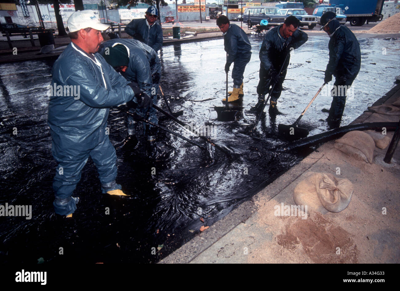 Arbeiter aufzuräumen und enthalten eine Ölkatastrophe in Long Island City-Queens eine Grundleitung führt aus einer Raffinerie in einem Vorratstank geplatzten Überflutung der Straße und einem kleinen Park mit Öl Stockfoto