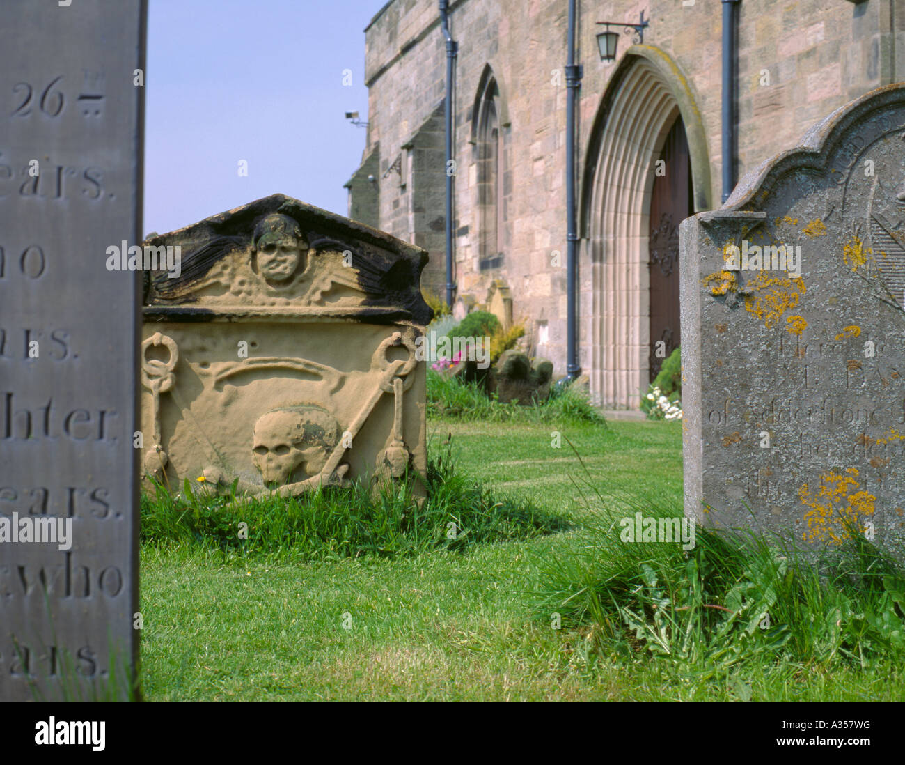 Grabsteine verschiedener Gesteinsarten, die in der St Aidan Kirchhof, bamburgh Dorf, Northumberland, England, UK. Stockfoto