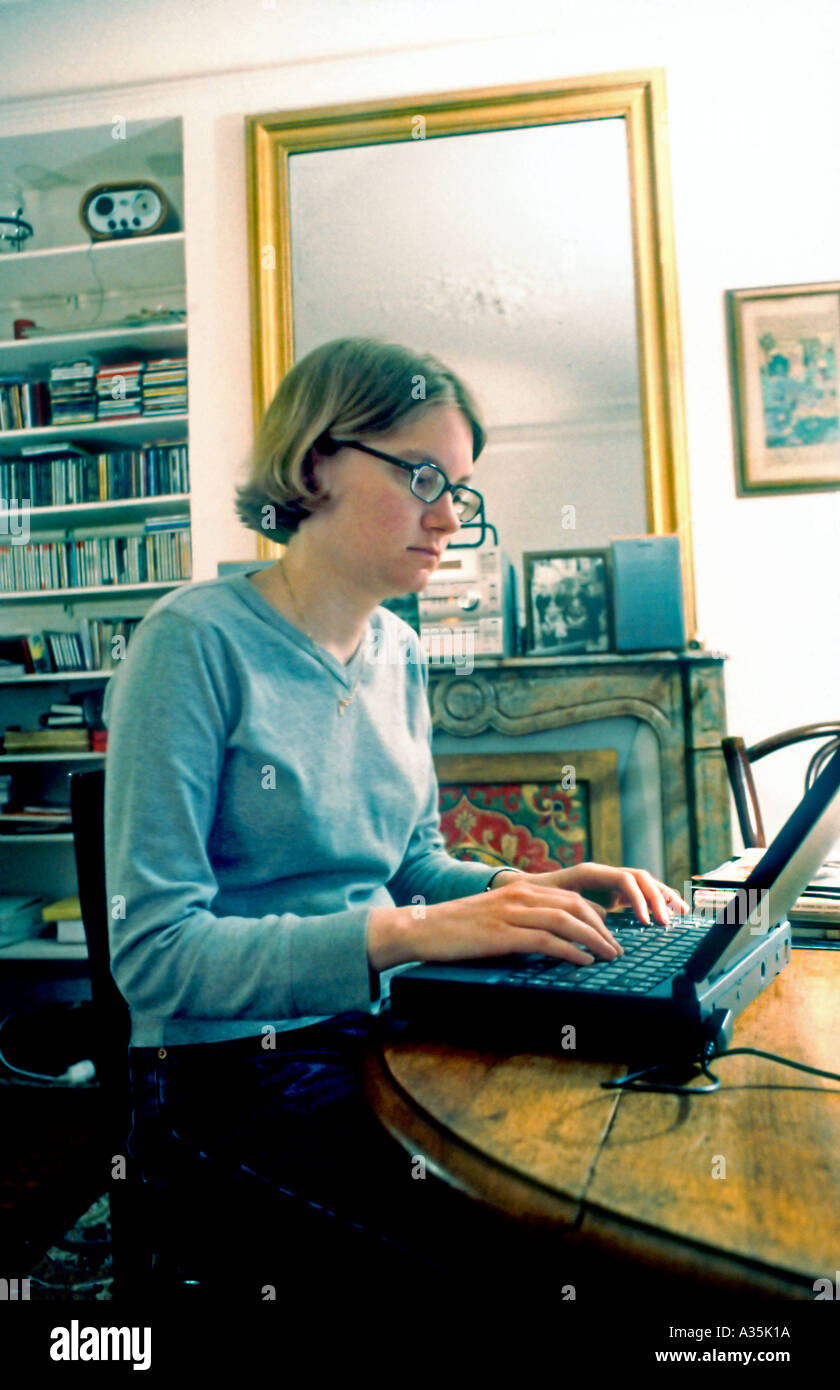 Junge Erwachsene, düstere Frau, die im Wohnzimmer im Home Office auf den Laptop-Bildschirm schaut, allein in der Nacht, Menschen arbeiten Stockfoto
