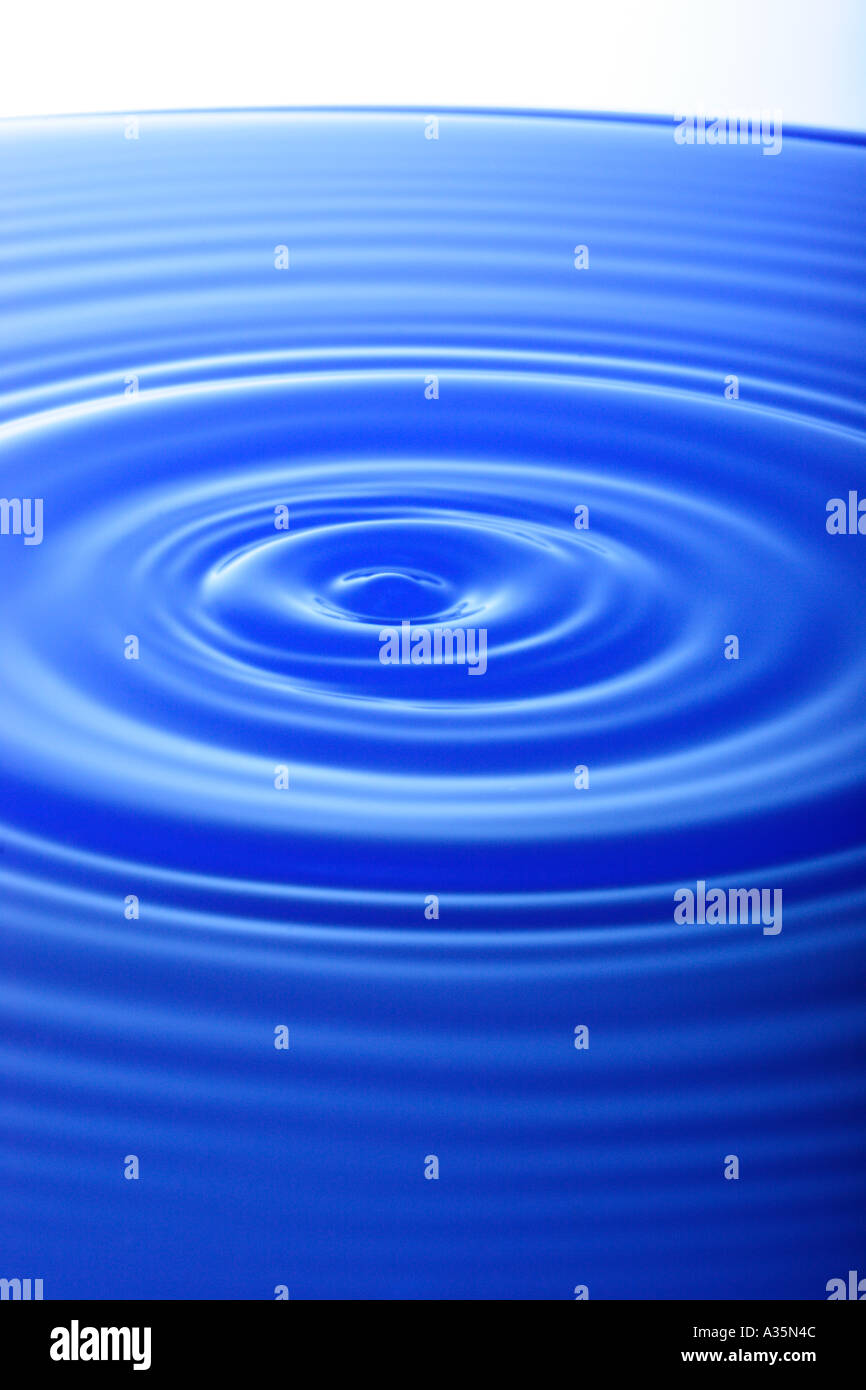 Tropfen Wasser macht Wellen auf der Wasseroberfläche Stockfoto