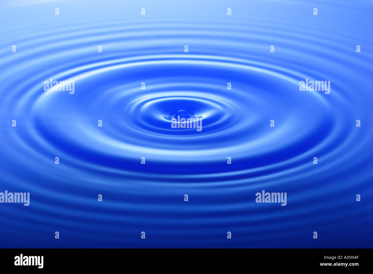 Tropfen Wasser macht Wellen auf der Wasseroberfläche Stockfoto
