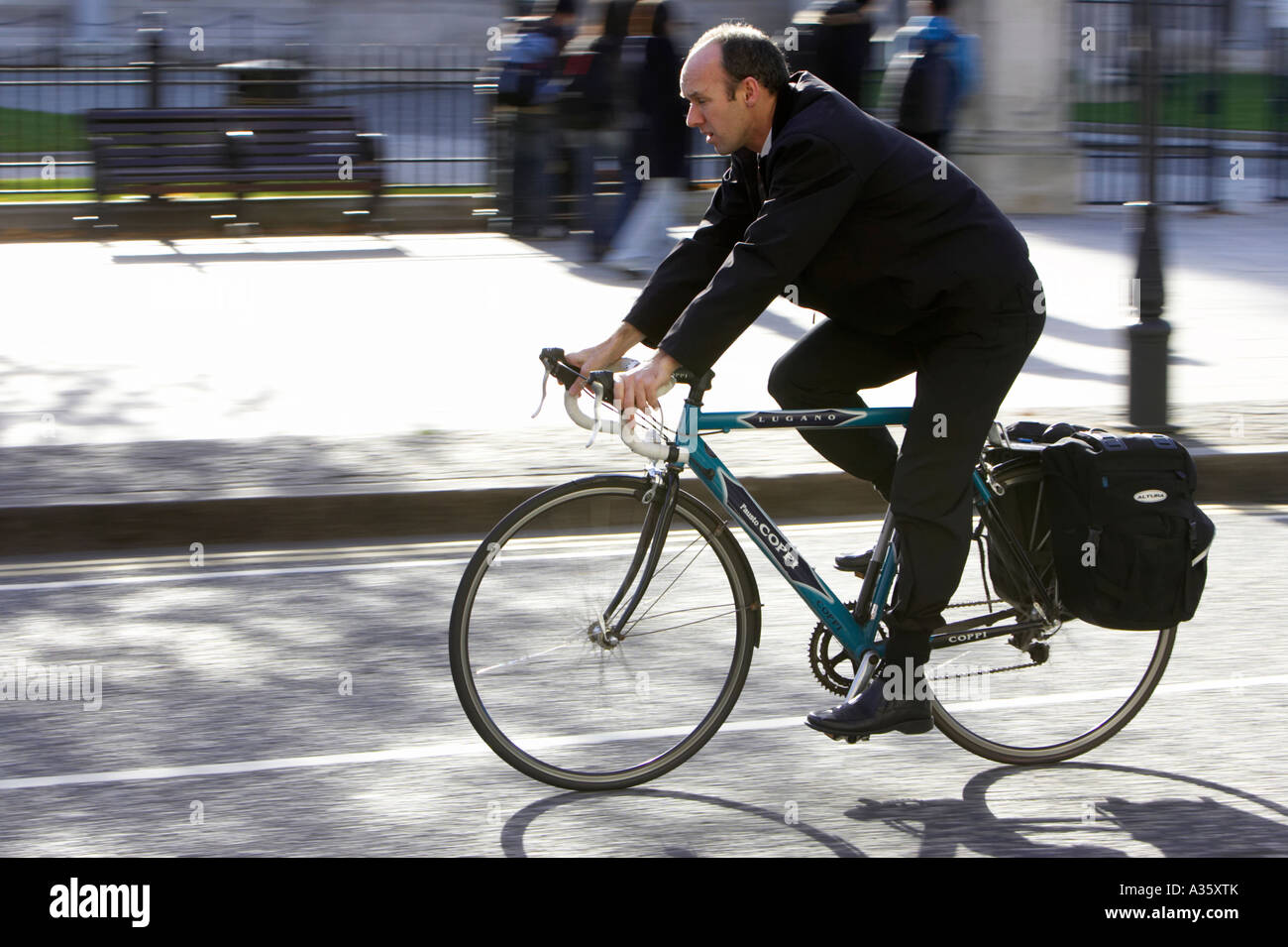 Glatze Mann Radfahren vorbei nach dem alten Stil Rennrad mit Satteltaschen unterwegs in einer Innenstadt Stockfoto