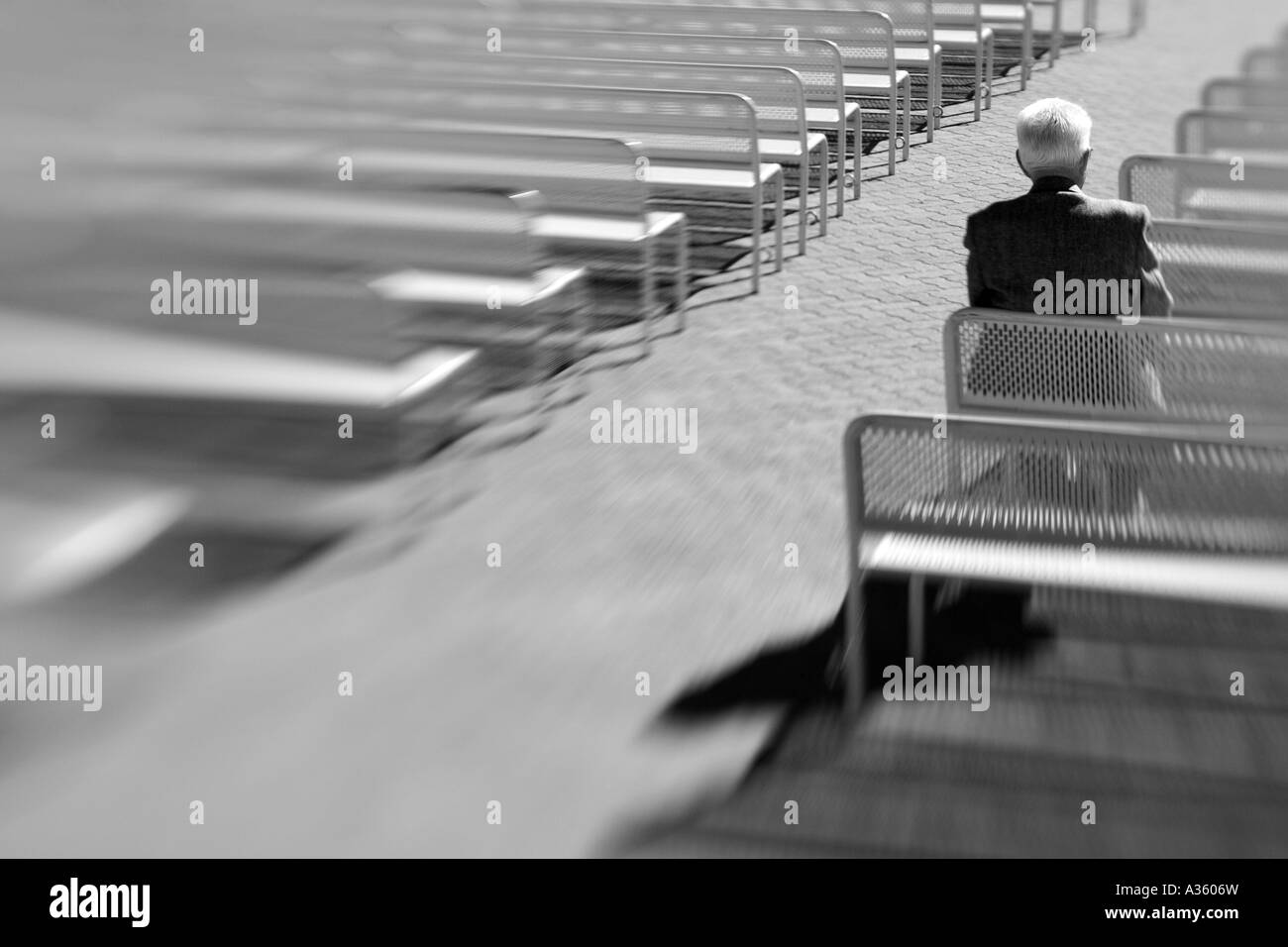 Ein starkes schwarz / weiß Bild eines alten Mannes allein auf einer Bank sitzen. Stockfoto