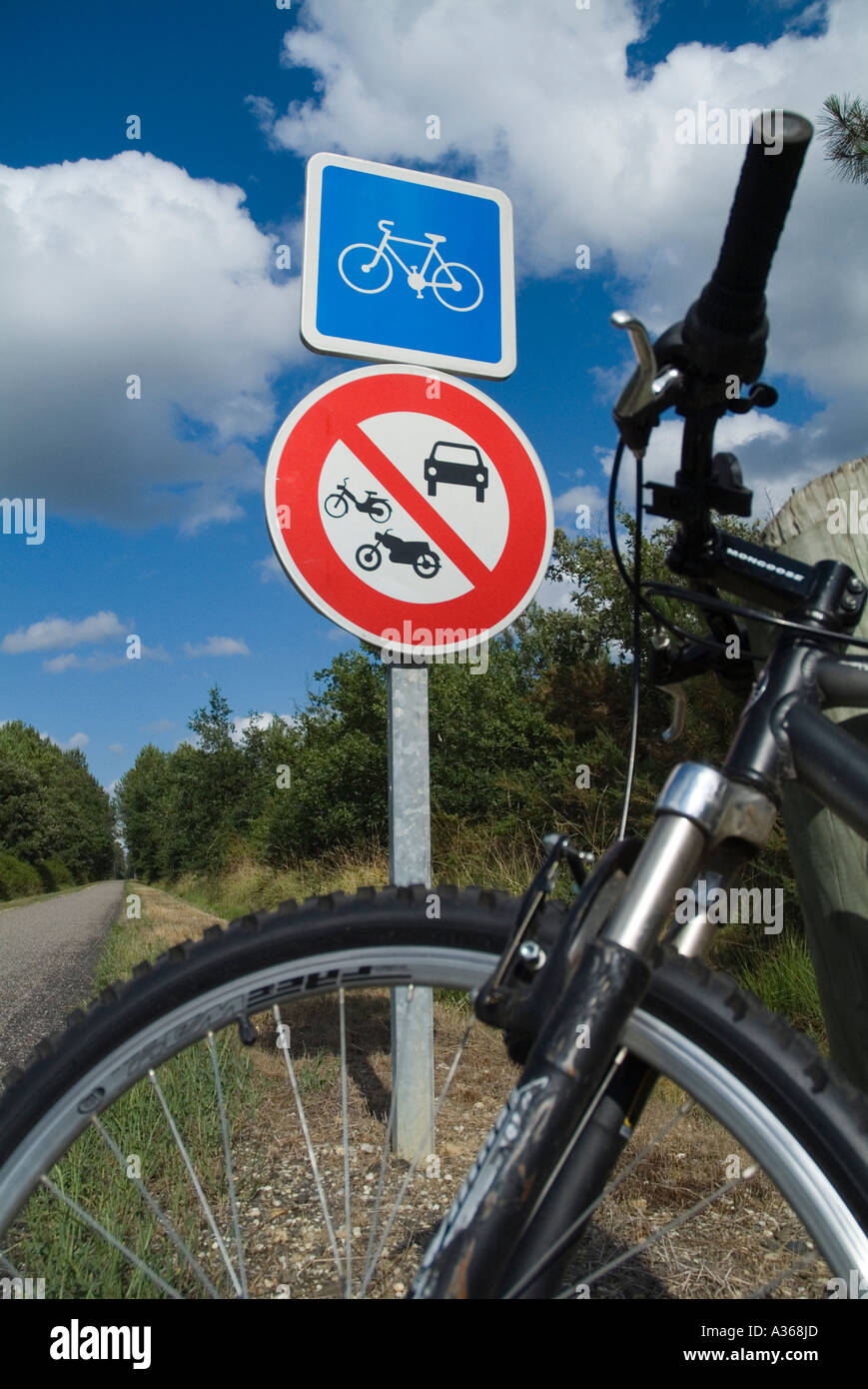 Fahrrad gegen ein Straße Zeichen-Pfosten auf einer Strecke durch den Wald der Landes Frankreich Aquitanien geparkt Stockfoto