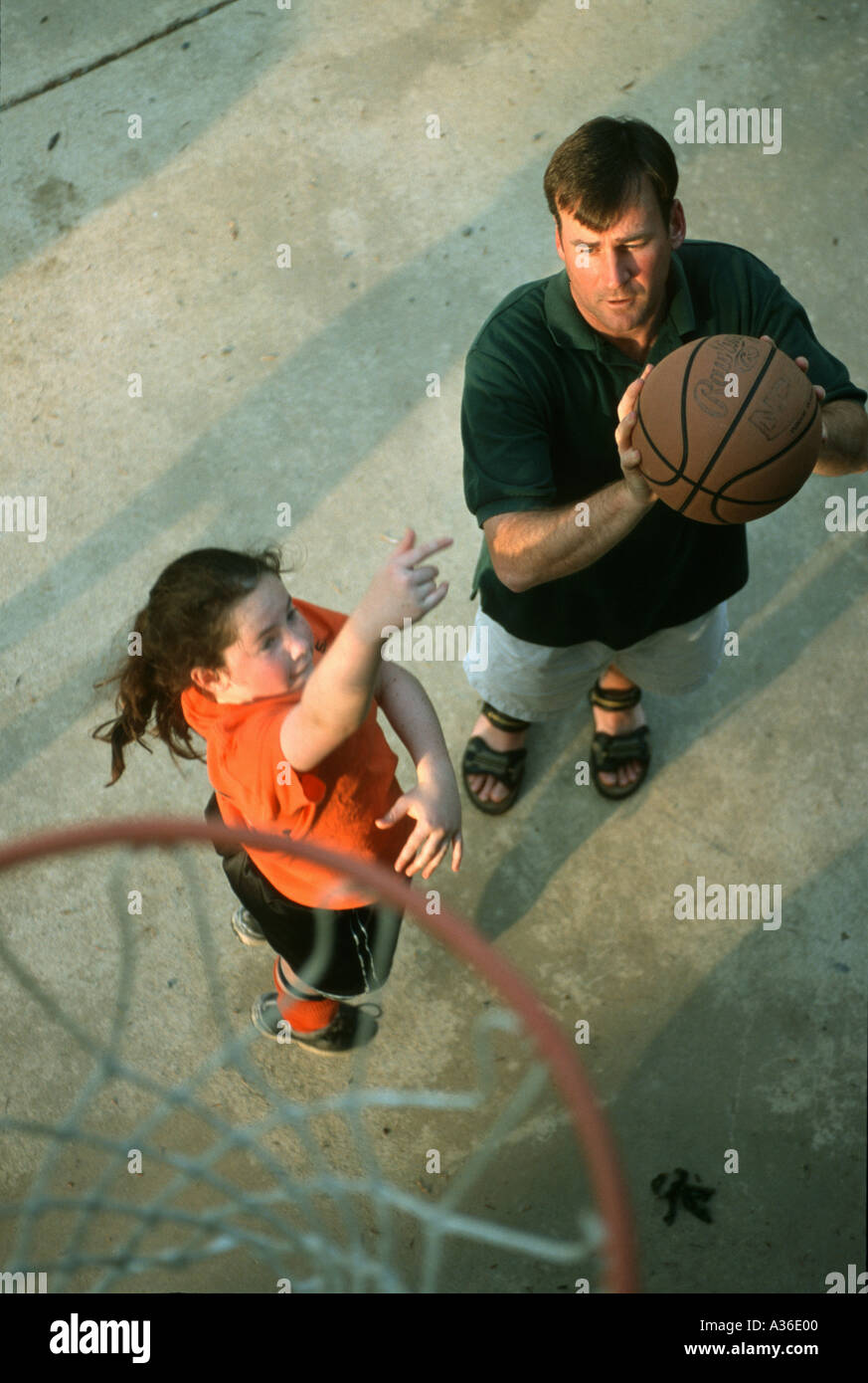 Ein Mann wird von oben als er gesehen, etwa um einen Korb zu schießen, während Sie Basketball spielen mit seiner Tochter außerhalb Stockfoto