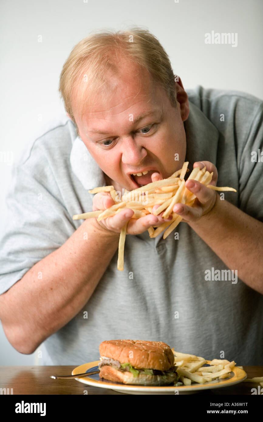 Menschen fressen auf Pommes frites oder dünne Späne mit einem Burger noch zu kommen Stockfoto