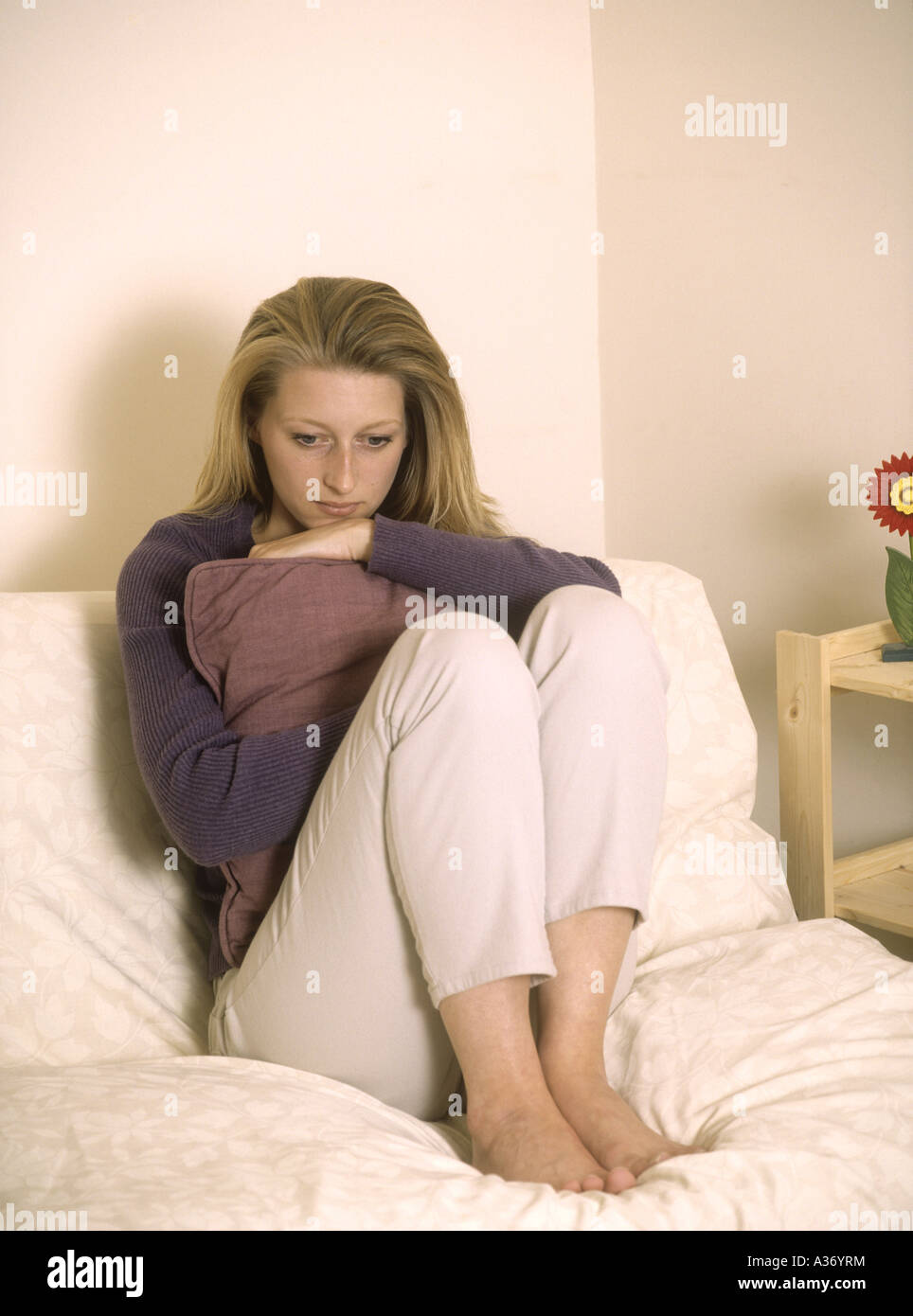 Junge Frau, die depressiv auf einem Sofa sitzt, britische Engländerin - Coronoviren, Kovid19-Kovid-19-Virus, Viren, England, Großbritannien, Großbritannien Stockfoto