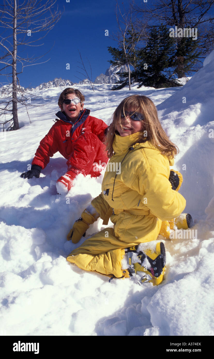 Zwei Kinder in Skianzüge spielen im Schnee Stockfoto