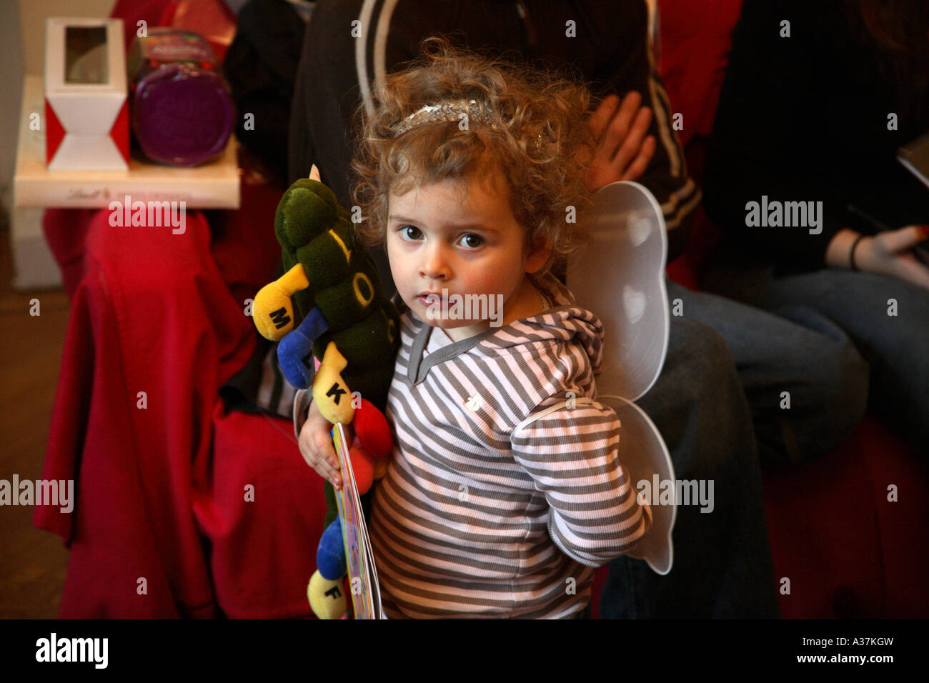 Drei Jahre altes Mädchen, das neues Spielzeug trägt, trägt Fairy Wings Stockfoto