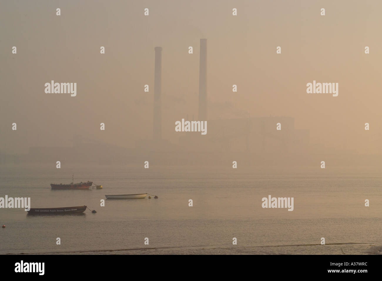 Die Schornsteine des Tilbury Kraftwerks erscheinen auf der anderen Seite des Flusses thames the Through Morning Mist Tilbury Power Station (abgerissen 2019) Stockfoto