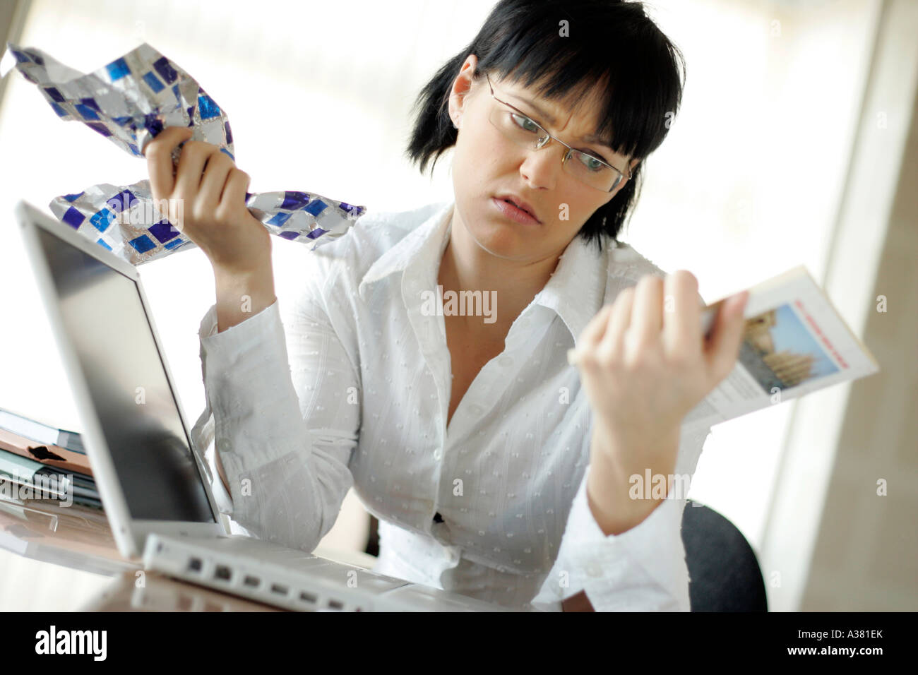 Frau im Büro schauen genervt mit einem Geschenk hat sie gerade ausgepackt. Stockfoto