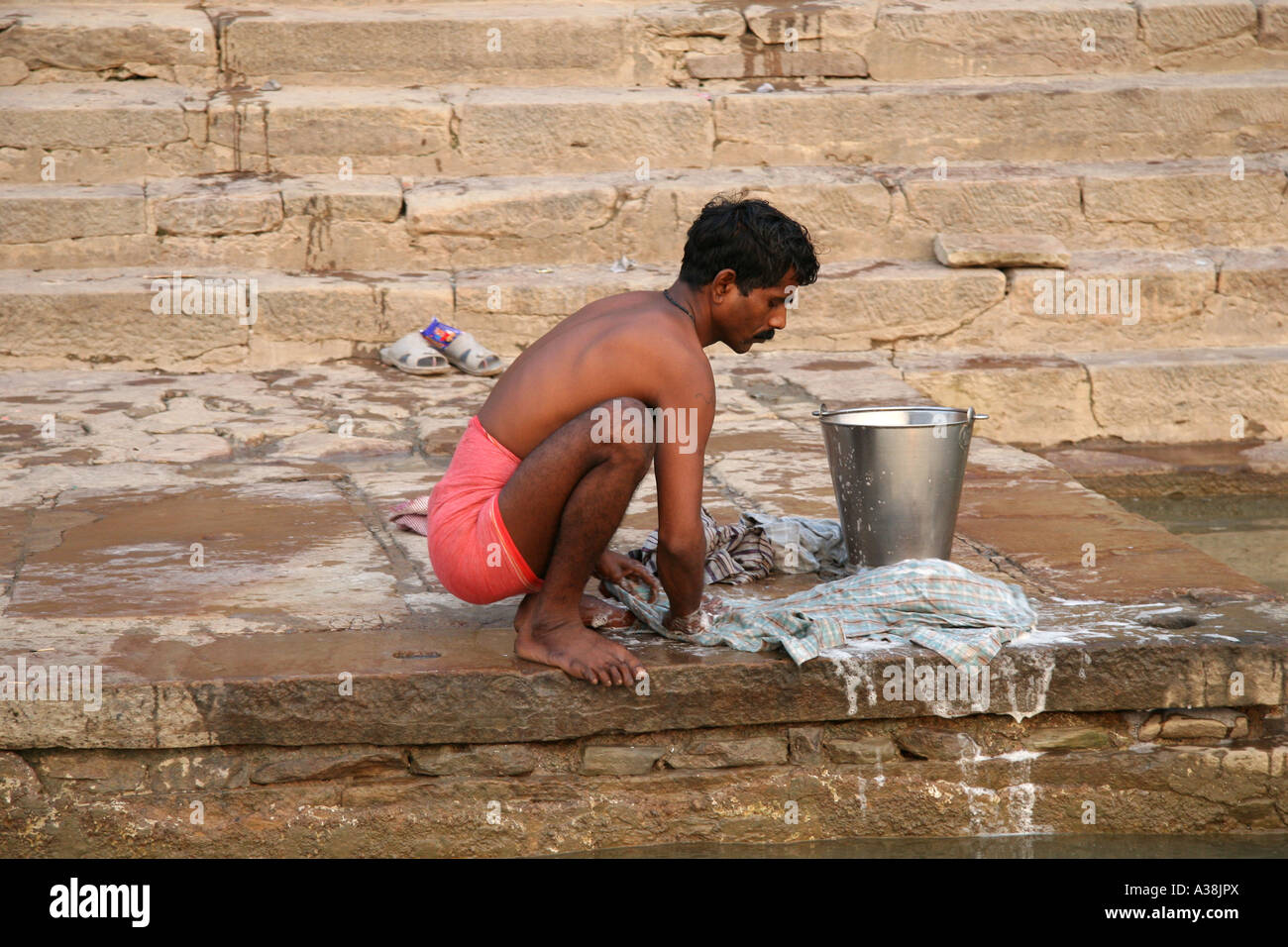 Lokale Mann tut seine Wäsche am Ufer des Flusses Ganges, Varanasi, Uttar Pradesh, Indien Stockfoto
