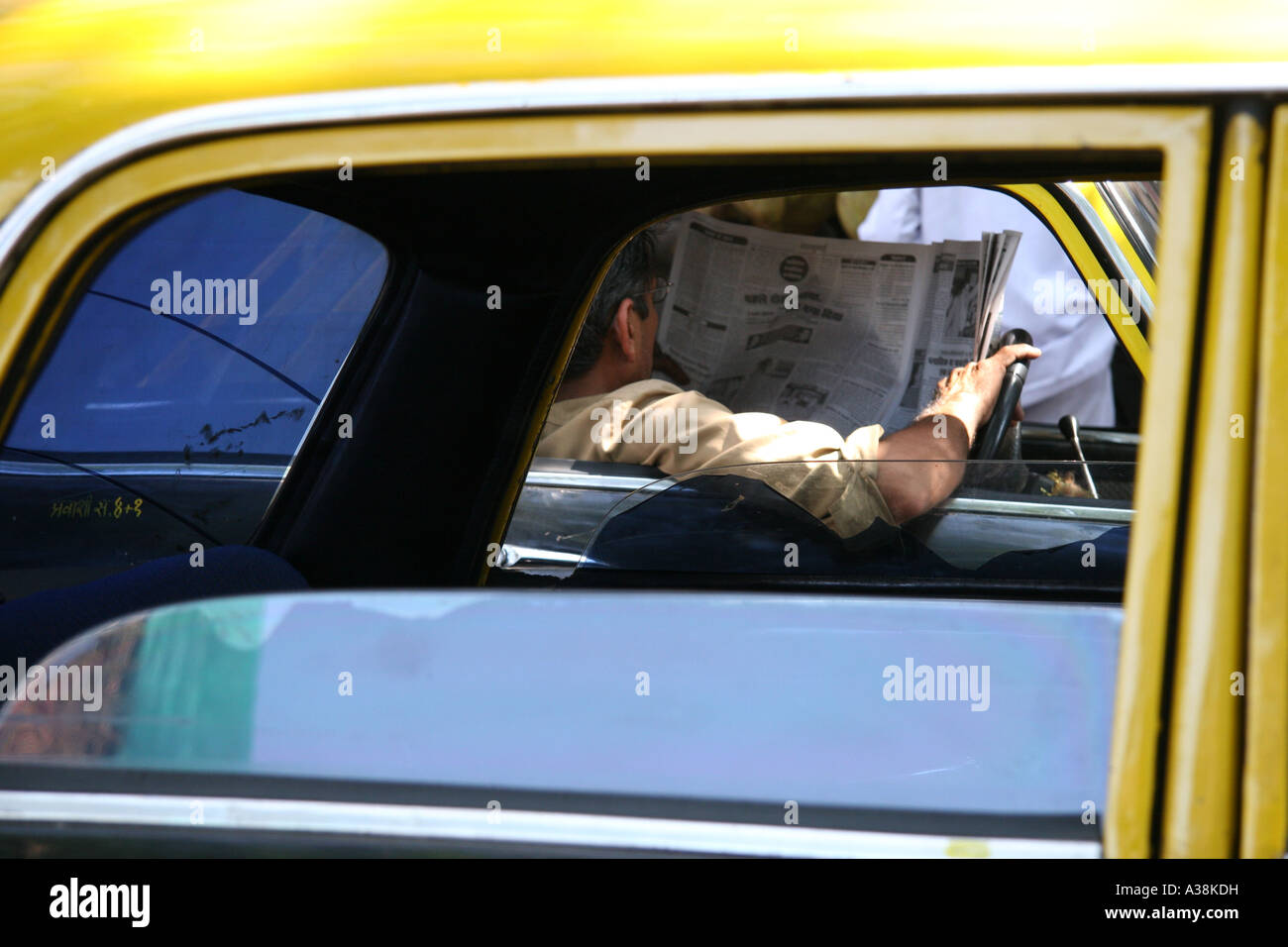 Taxifahrer seine Zeitung lesen, während der Einnahme einer Pause in Mumbai, Maharashtra, India Stockfoto