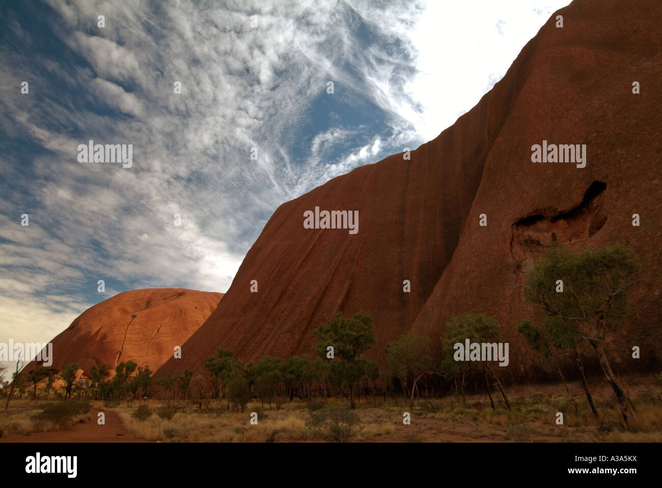 Ayers Rock kurz nach Sonnenaufgang wie entlang der Basis gehen um Uluru gesehen Stockfoto