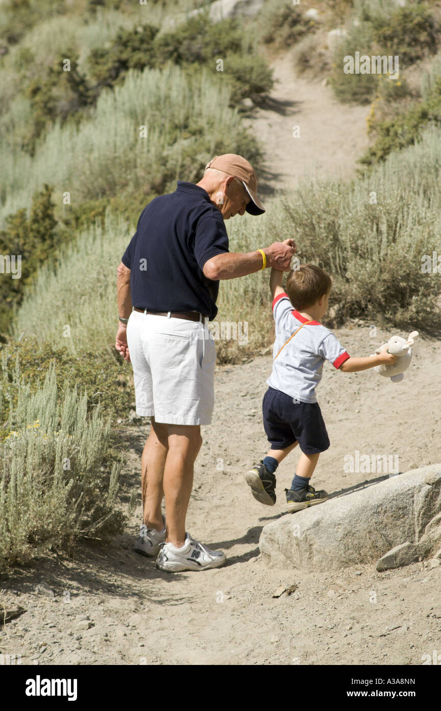 Großvater und Enkel helfen, Wandern, die Natur zu Fuß entdecken junge alte Mann Hilfe Hilfe Pflege Unterstützung zu überwinden Hindernisse Stockfoto