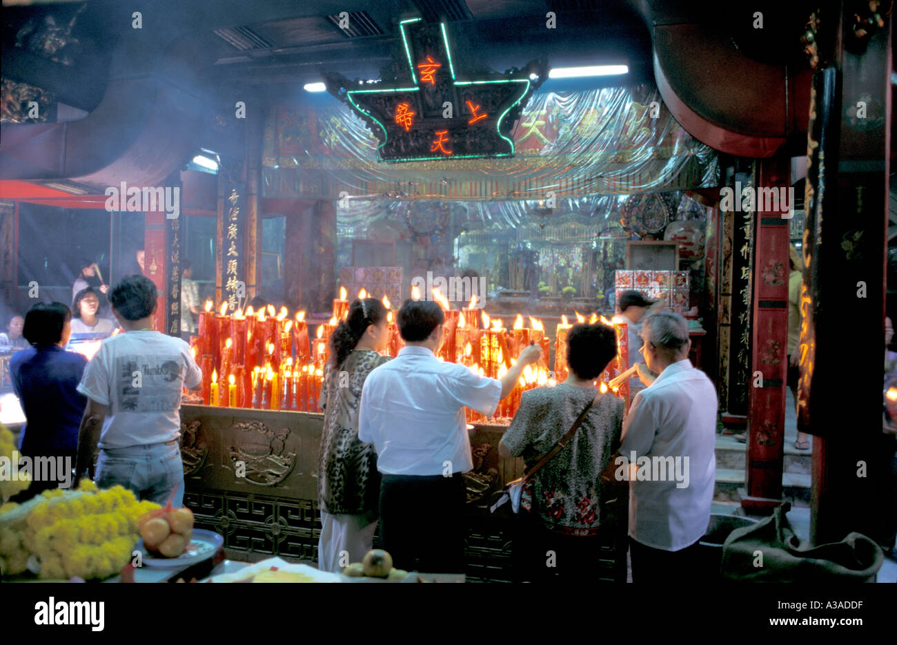 Innenraum der Sanjao Pho Sua Chinese Temple aka Vater Tiger Tempel, mit Anbeter beleuchtung rot Wachs Kerzen, Thanon Tanao, Bangkok, Thailand Stockfoto