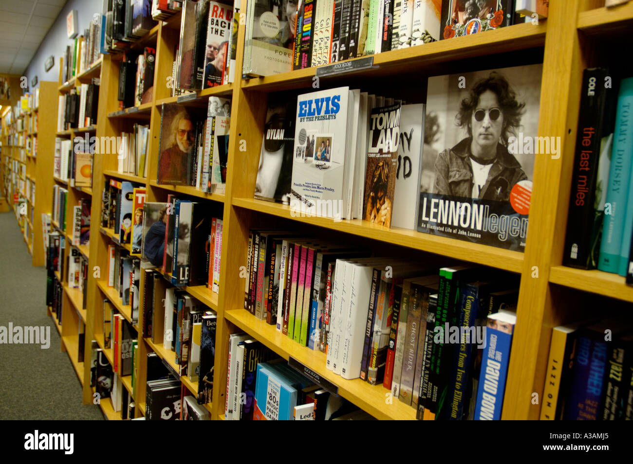 Regale für Bücher in einem Buch Einzelhandelsgeschäft John Lennon, Elvis, deckt Biografie anzeigen Stockfoto