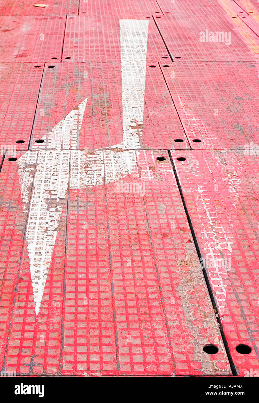 Weißer Verkehr Kontrolle Pfeile aufgemalt Metall rot flloor Stockfoto