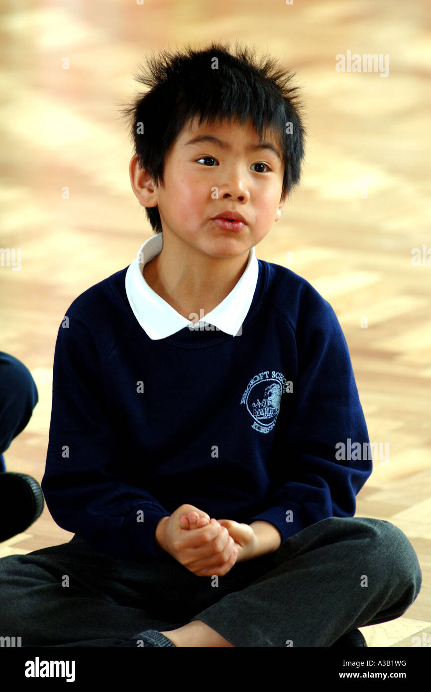 Chinesischer Junge hört der Lehrer an einer Grundschule Leeds Stockfoto