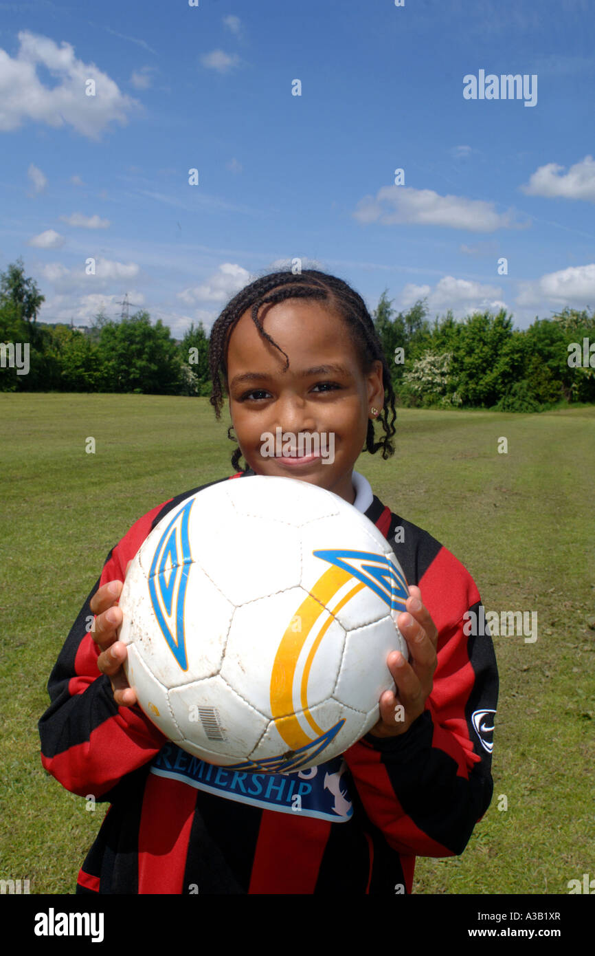 Mädchen hält einen Fußball auf dem Spielfeld Schule West Yorkshire Stockfoto