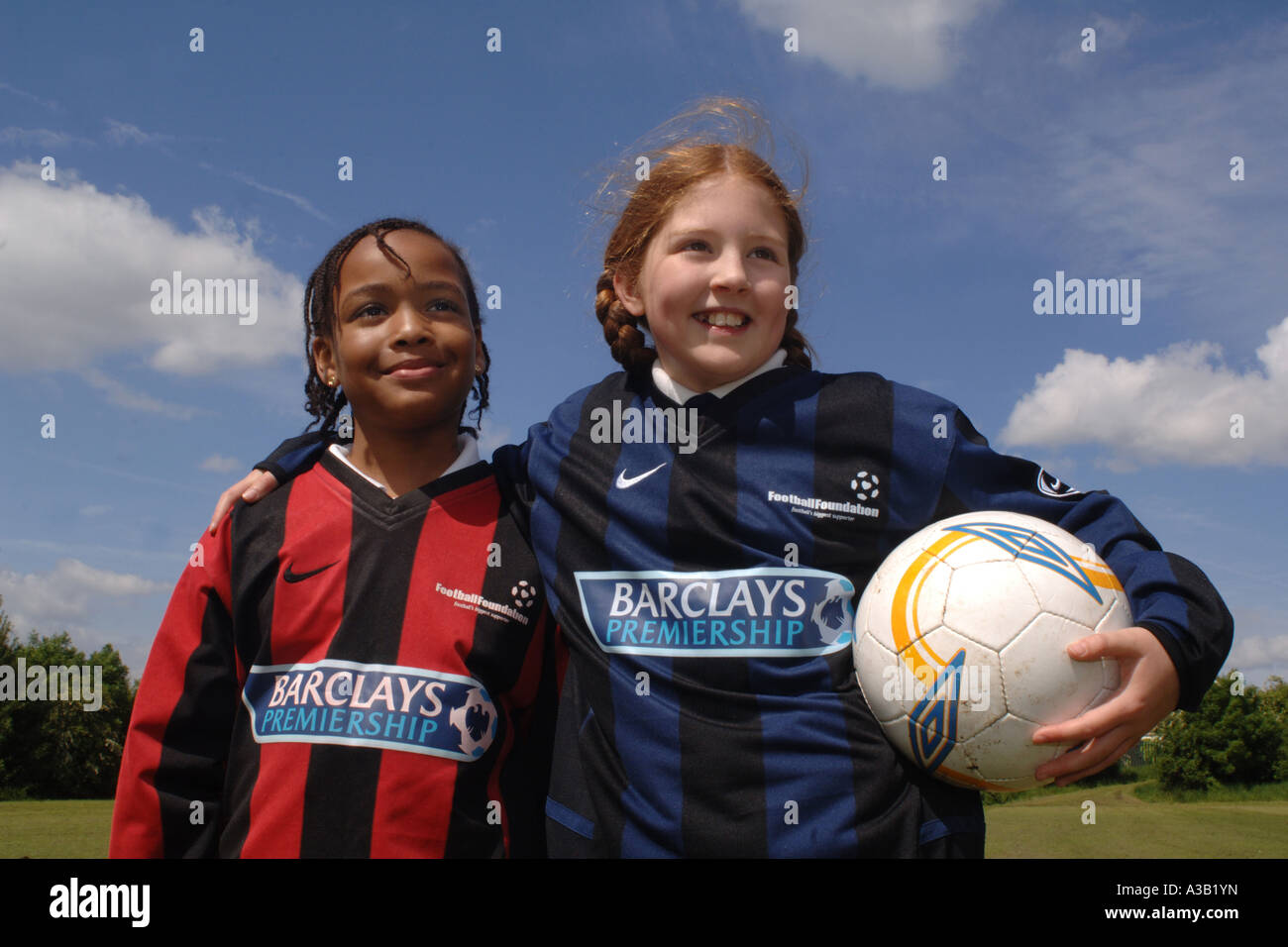 Mädchen mit ihrer Fußball-Team auf dem Spielfeld Schule West Yorkshire anzufeuern Stockfoto