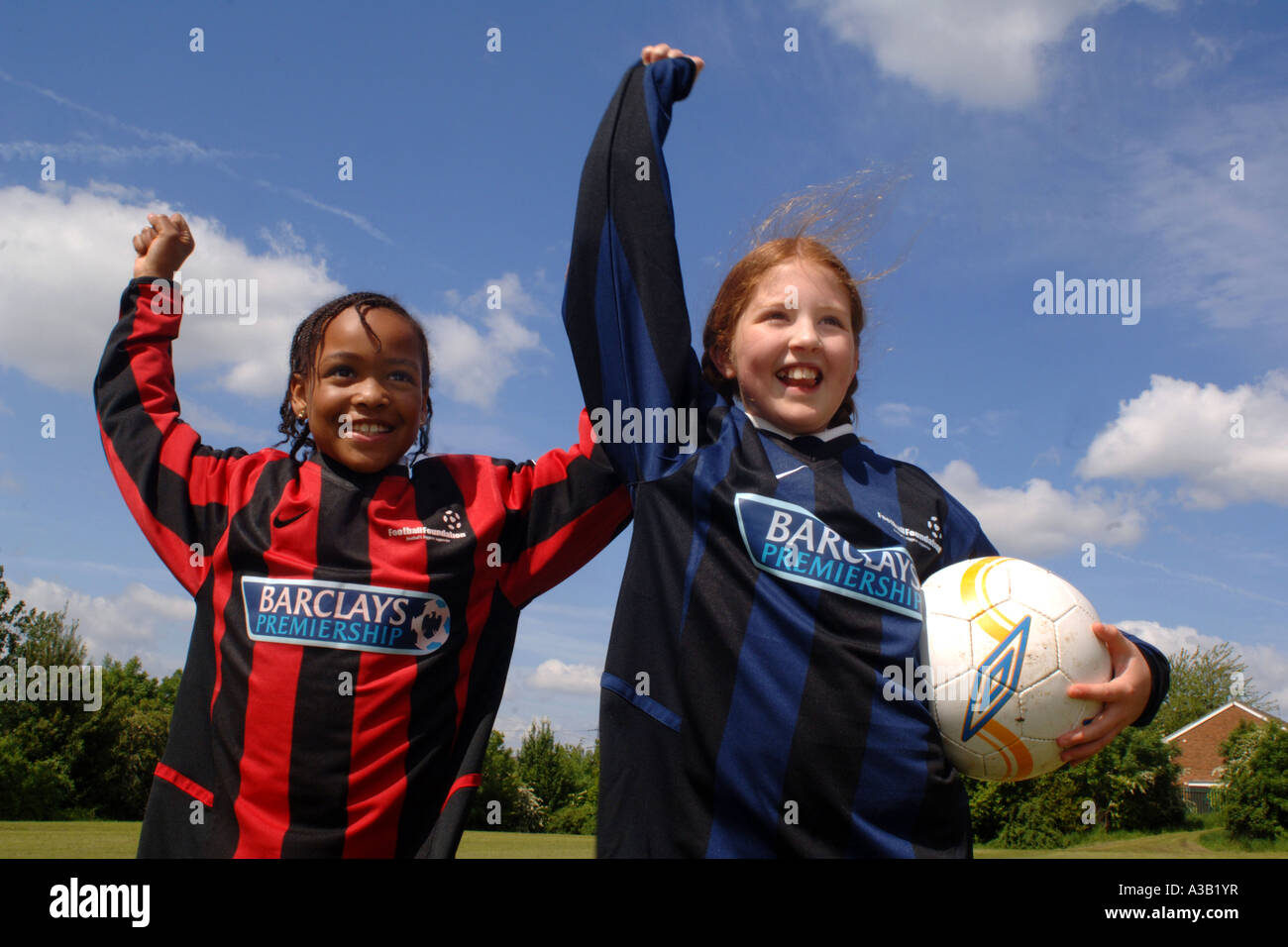 Mädchen mit ihrer Fußball-Team auf dem Spielfeld Schule West Yorkshire anzufeuern Stockfoto