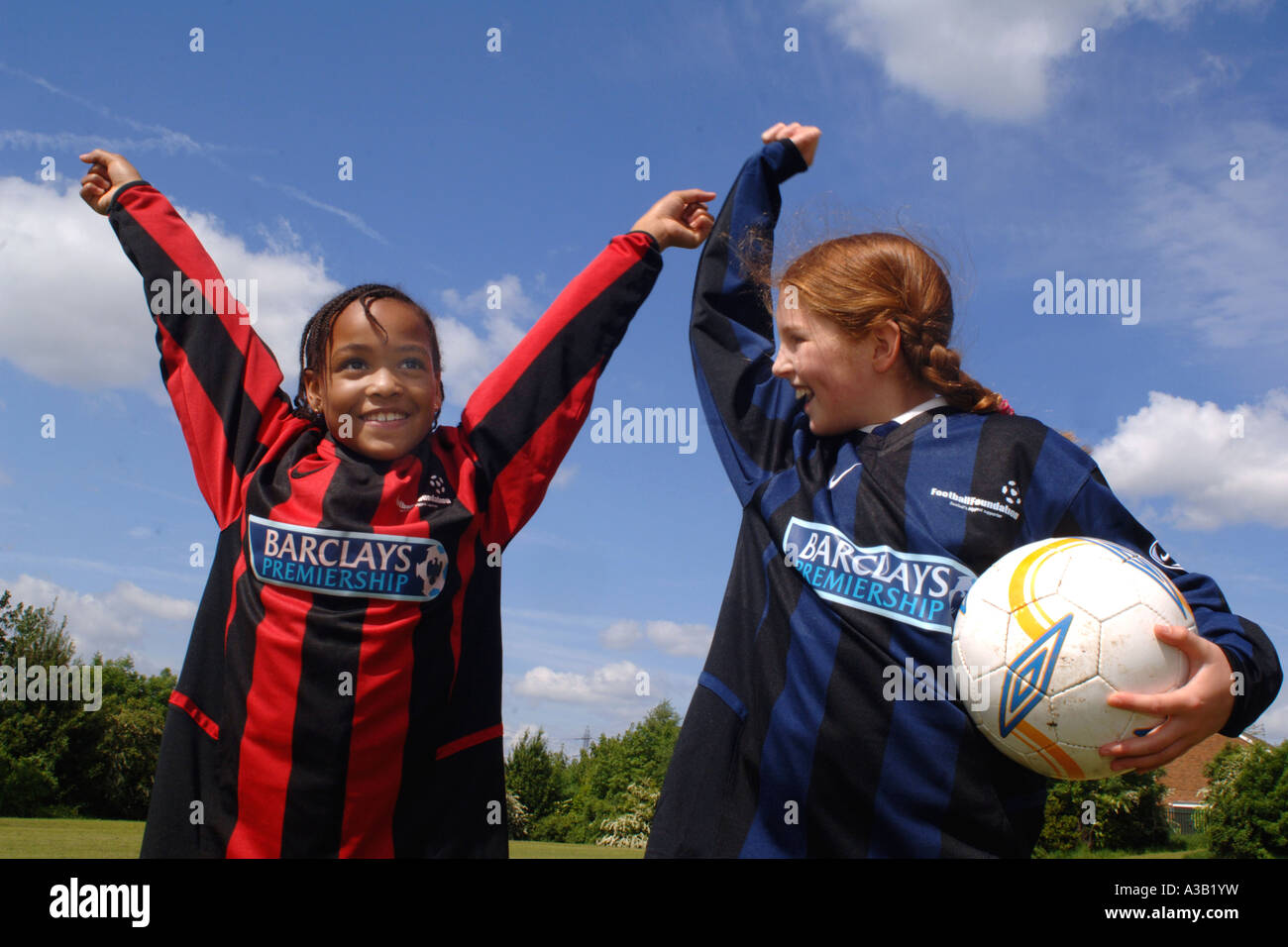 Mädchen mit ihrer Fußball-Team auf dem Spielfeld Schule West Yorkshire anzufeuern Stockfoto