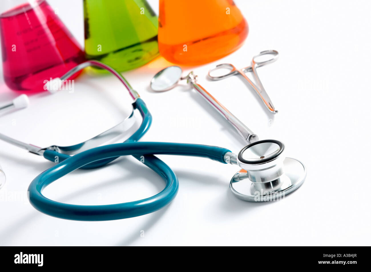 Eine dunkle blaue Stethoskop Chirurgen Zange und Lab Ausrüstung auf einem weißen Hintergrund mit sterilen aussehende hohe Schlüsselstil Stockfoto