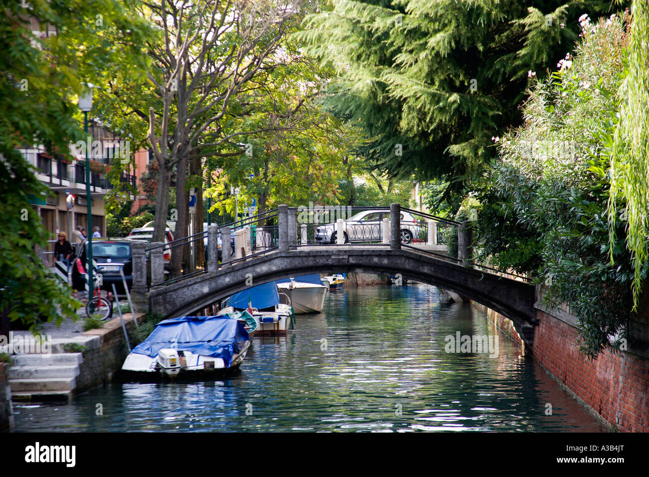 Italien Venetien Venedig Lido A Fußgängerbrücke über einen kleinen Kanal mit Booten vertäut auf der einen Seite. Stockfoto