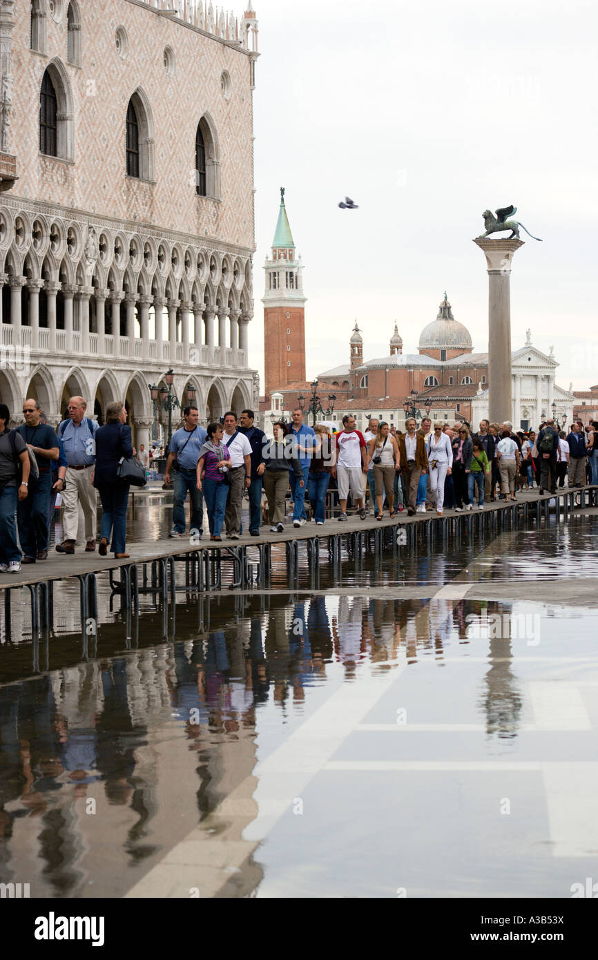 Italien Venetien Venedig St. Mark's Square Aqua Alta Hochwasser Überschwemmung Touristen auf erhöhten Gehweg außerhalb Dogenpalast in piazzetta Stockfoto