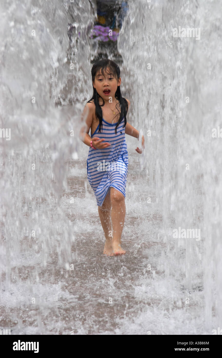 Junges Mädchen läuft durch Brunnen Stockfoto
