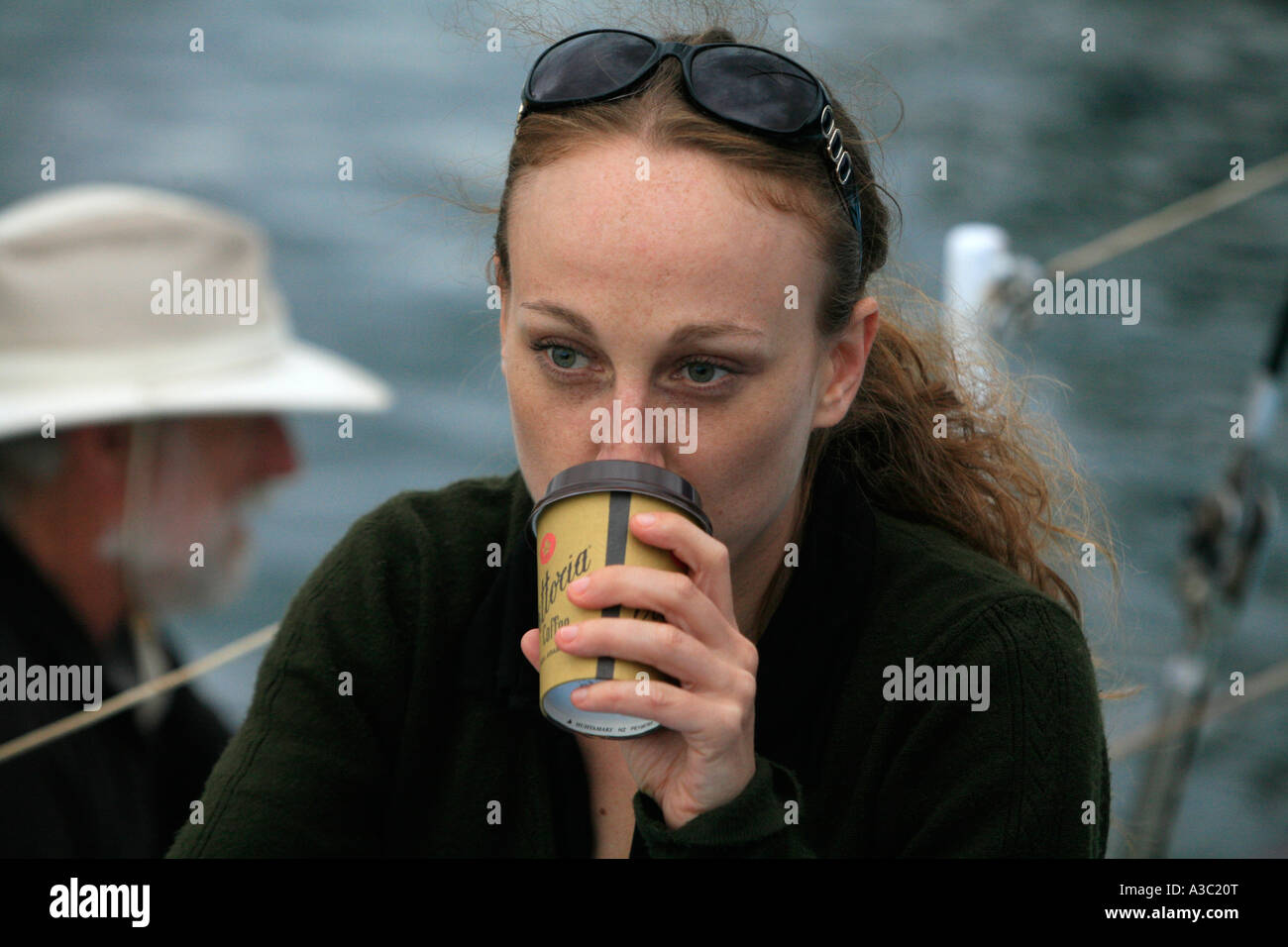 Eine junge Frau trinkt eine nehmen Sie Kaffee in Einweg-Becher Stockfoto