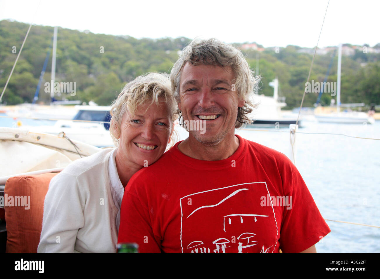 Ein attraktives australische mittleren gealterten paar Lächeln zusammen auf einem Boot Stockfoto