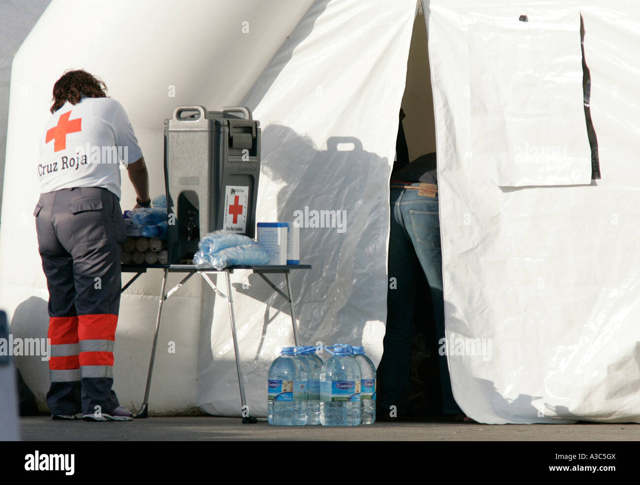 Spanisches rotes Kreuz Cruz Roja Arbeitnehmerin vor weißen medizinischen Zelt bereitet zur Behandlung von illegaler Einwanderern Stockfoto