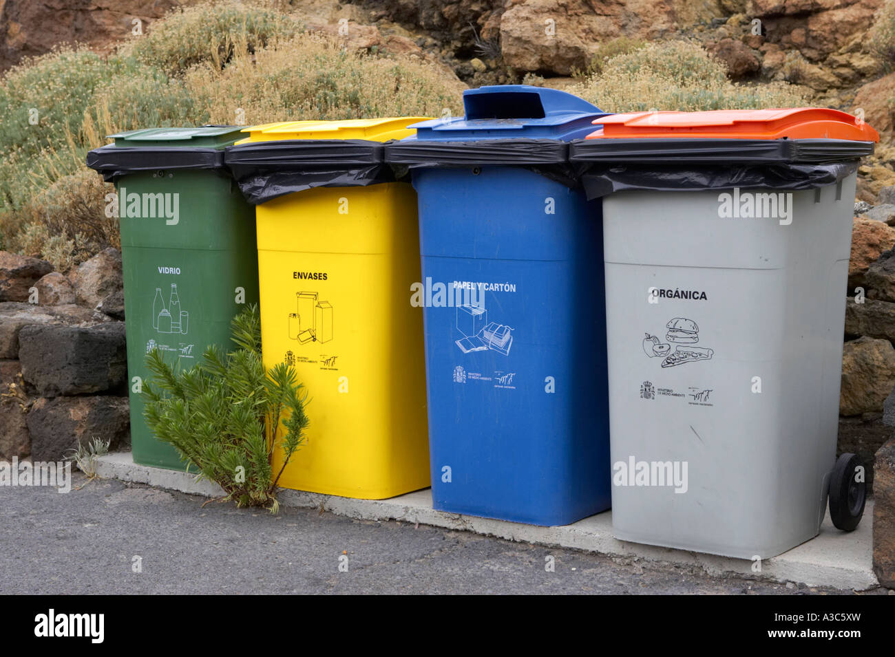 grün gelb blau und grau Glas Verpackung Karton Papier und Bio recycling Wheelie-Behälter in Los Roques Teneriffa Stockfoto