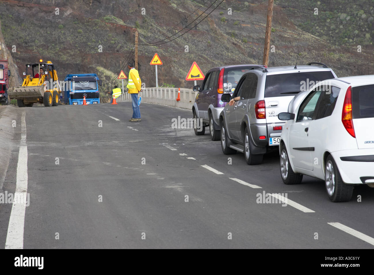 spanischer Straßenarbeiter schaut auf Baustellen an Küsten Klippenstraße geben das Signal gehe auf Teneriffa-Kanarische Inseln-Spanien Stockfoto