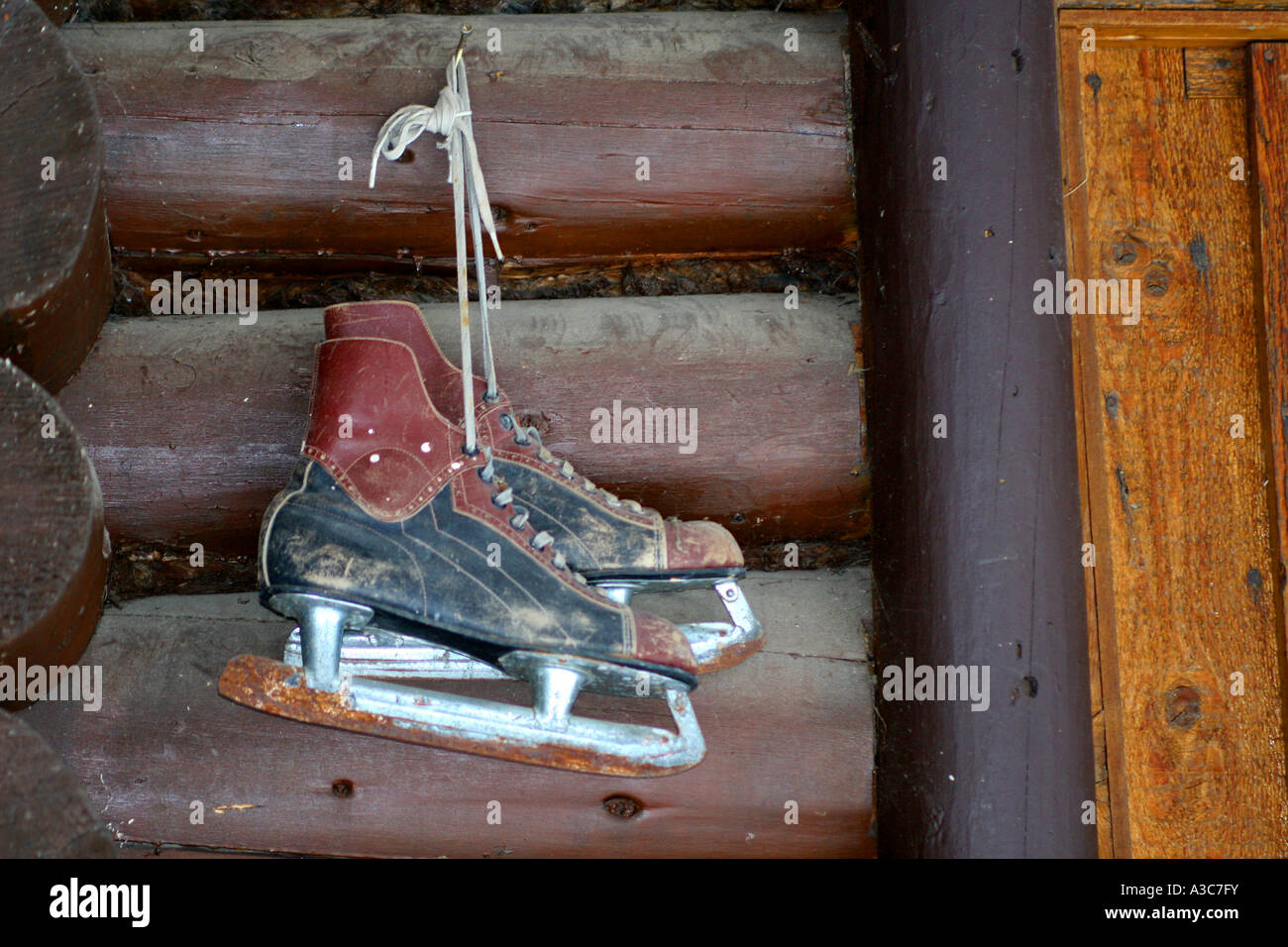 Schlittschuhe an einem Blockhaus Wand hängen Stockfoto