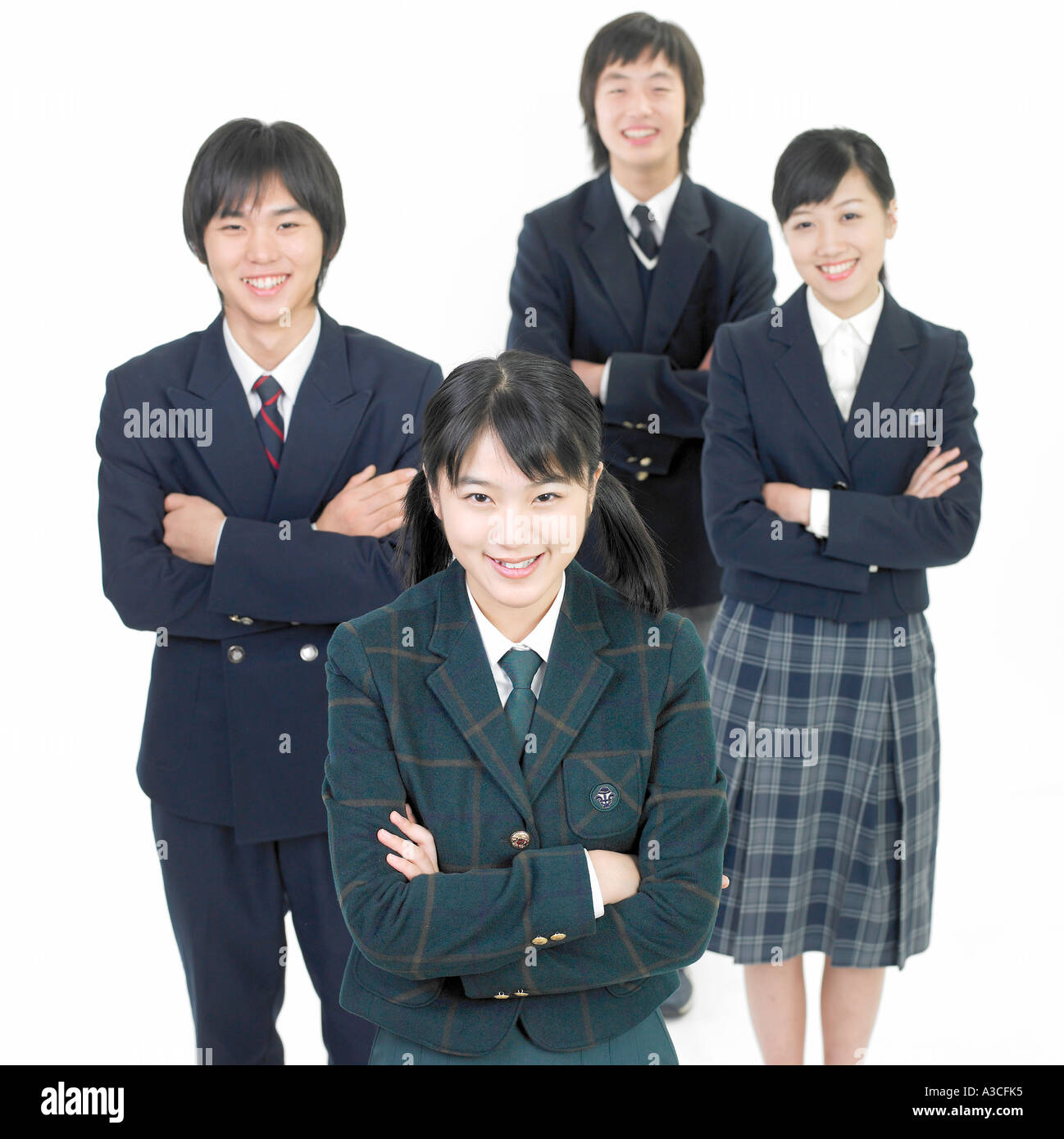 Vier Studenten stehen und ihre Arme kreuzen Stockfoto