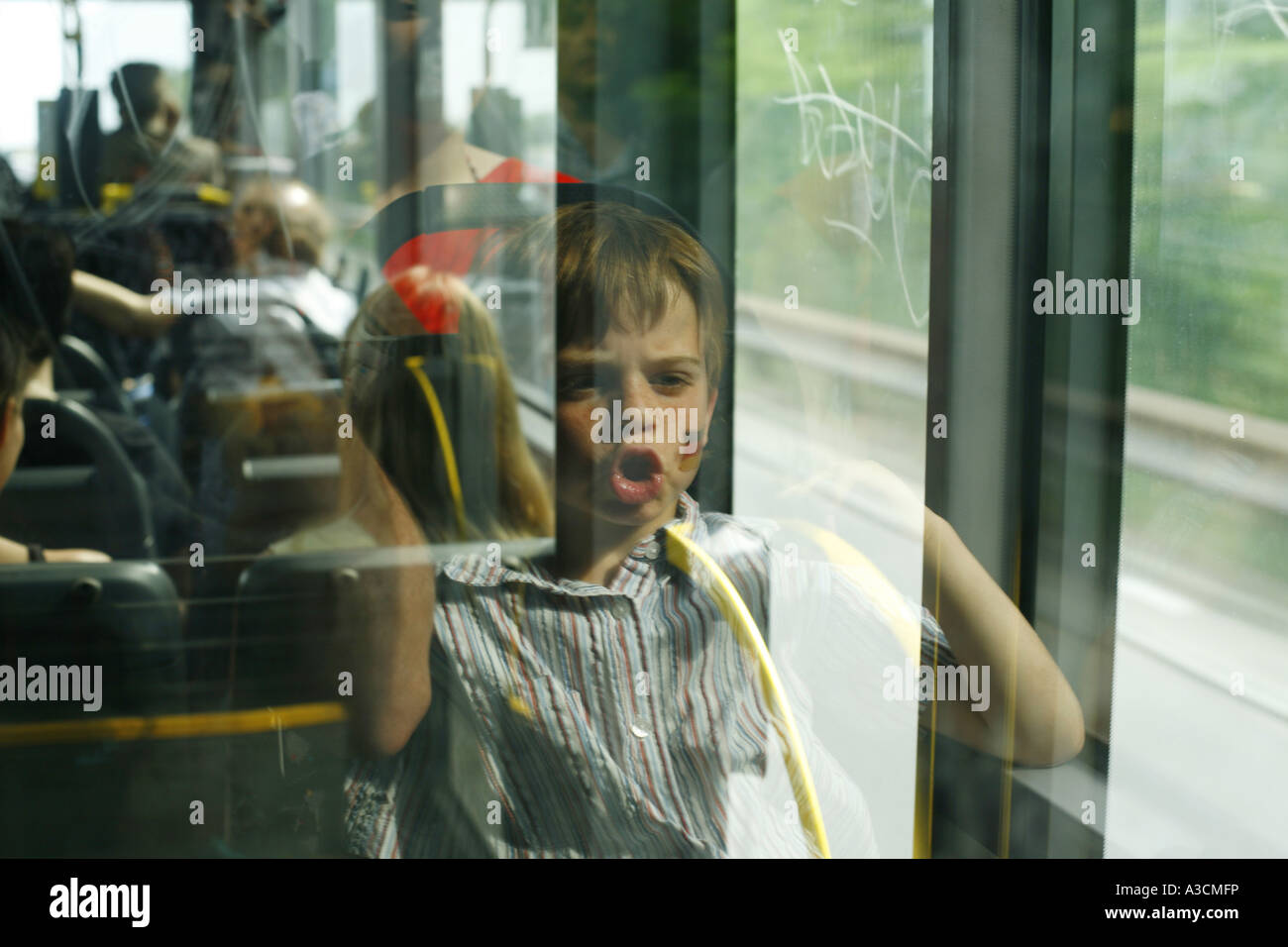 Kind in einem Busfenster spiegeln die deutsche Flagge gemalt auf die Wange, Deutschland, Berlin Stockfoto