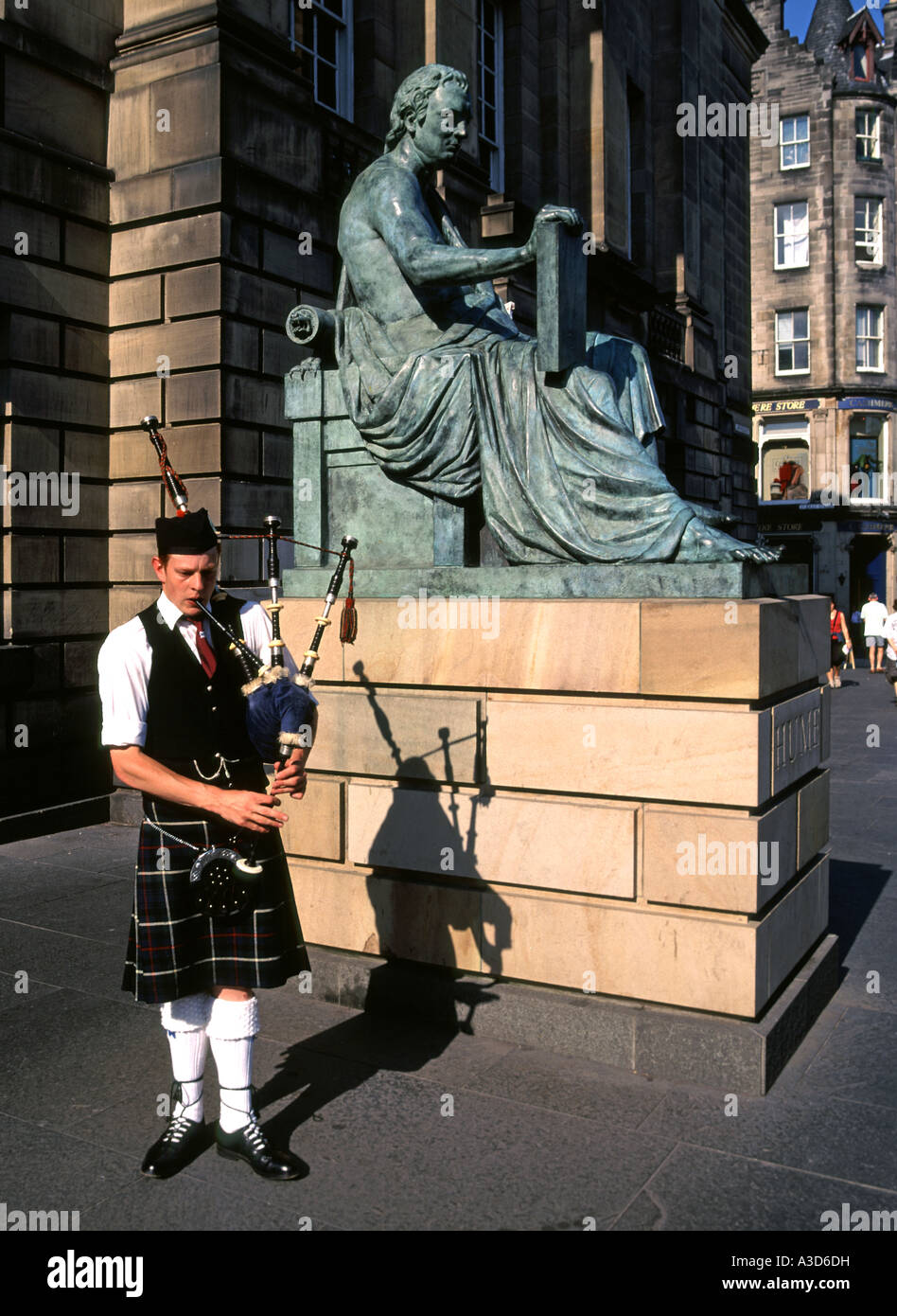 Mann spielt Dudelsack neben der Statue des David Hume (vom Bildhauer Alexander Stoddart) außerhalb der High Court von Justiciary in Edinburgh Schottland Großbritannien Stockfoto
