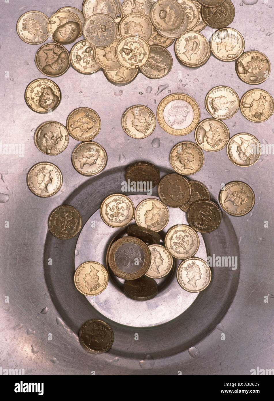 Geld auf der Abfluss-Konzept-Bild zeigt Pfund Münzen in Richtung Abfluss im Waschbecken gewaschen Stockfoto