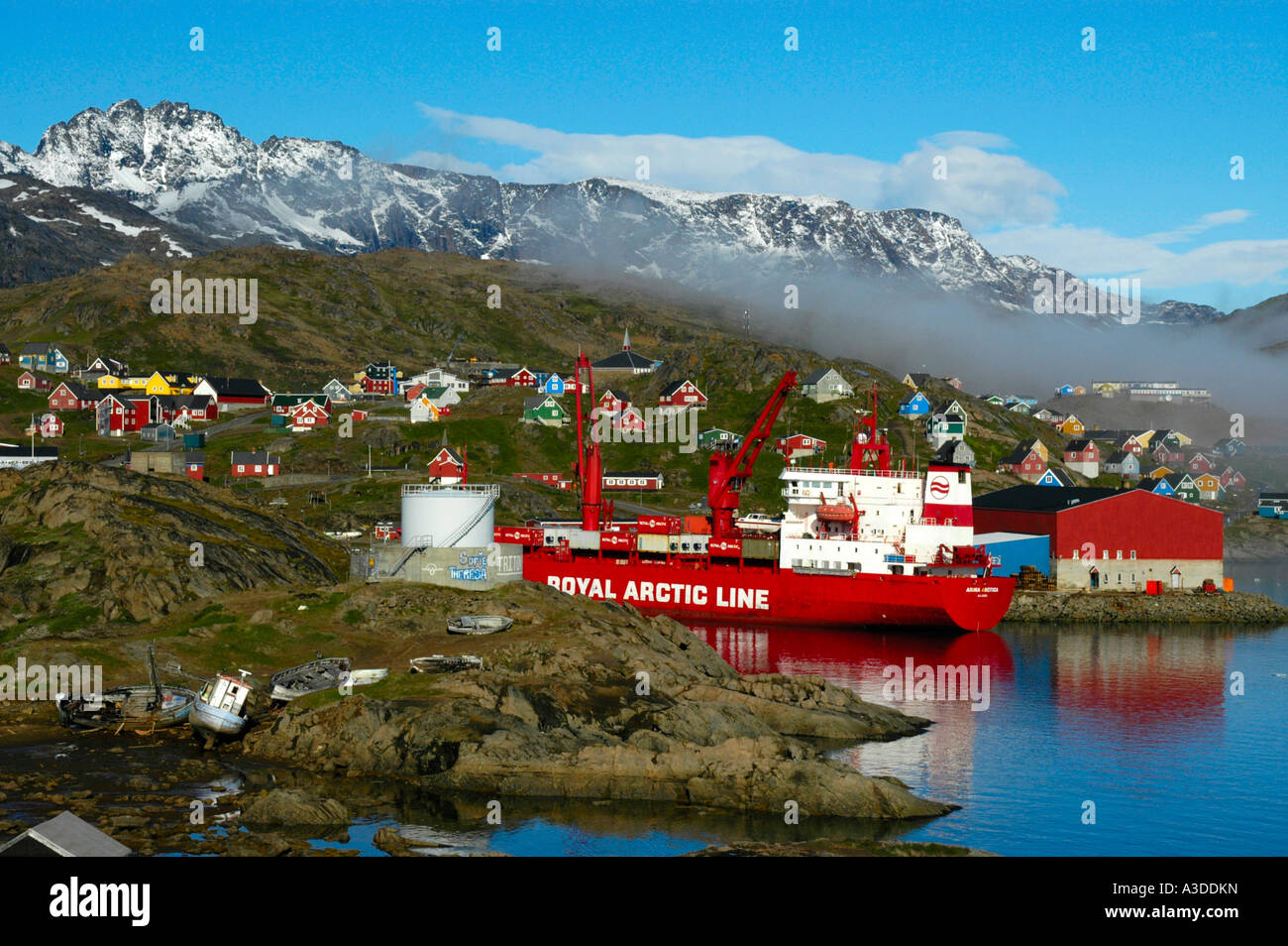 Containerschiff der Royal Arctic Line im Hafen der Stadt mit bunten Häuser Ammassalik Eastgreenland Stockfoto