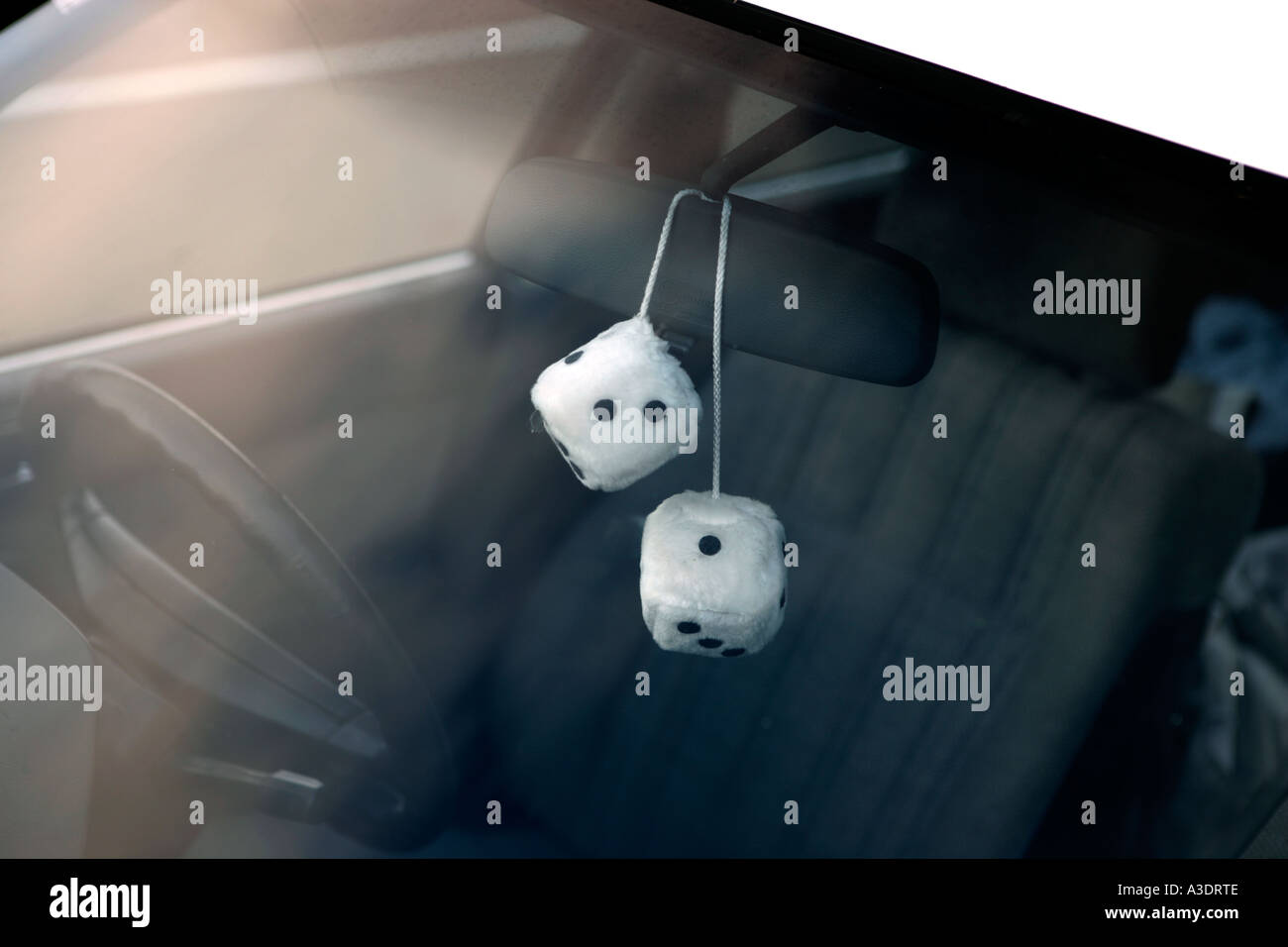 Zwei flauschige Würfel Rückspiegel eines Autos, gesehen durch die  Windschutzscheibe hängen Stockfotografie - Alamy